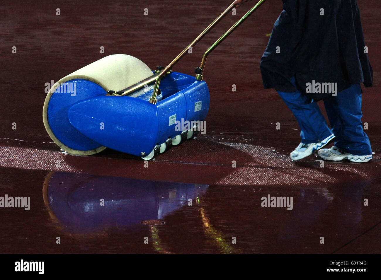 Atletica - Campionati mondiali di atletica IAAF - Helsinki 2005 - Stadio Olimpico. Un membro del personale sgomma l'acqua piovana dalla pista con una macchina rotolatrice Foto Stock