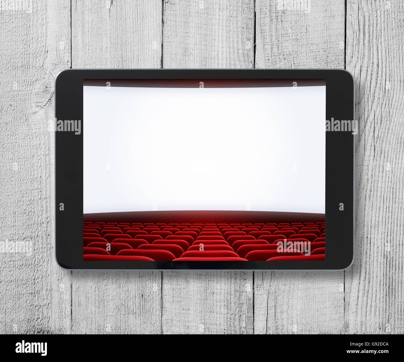 Tablet PC su un tavolo di legno con cinema schermo visualizzato. Foto Stock