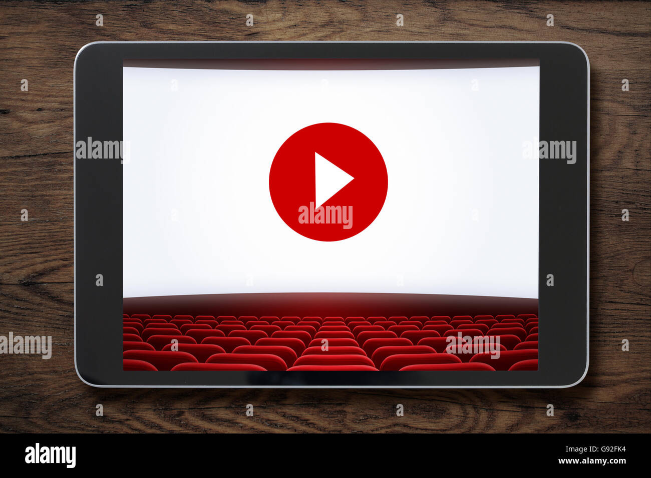 Tablet PC su un tavolo di legno con cinema schermo visualizzato. Foto Stock