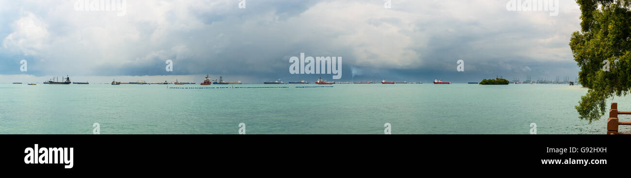 Vista panoramica del Singapore stretto da l'Isola di Sentosa. Navi, paesaggio industriale e le tempeste. Foto Stock