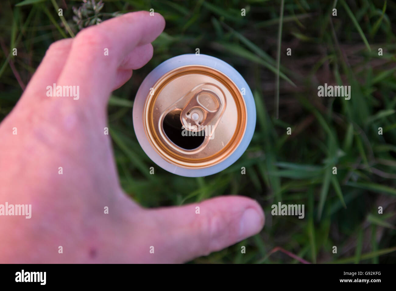Una lattina di birra viene prelevato dal pavimento Foto Stock