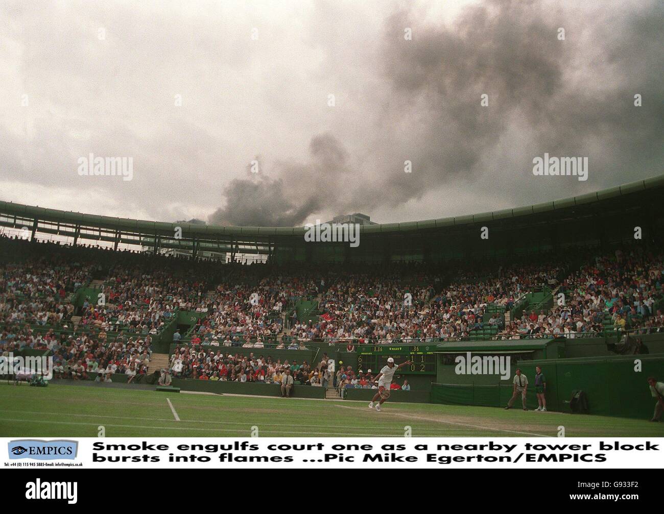 Tennis - Wimbledon Championship - Singles Donna - Round Three - Monica Seles / Yayuk Basuki. Il fumo ingulfs campo uno come un vicino blocco torre scoppia in fiamme Foto Stock