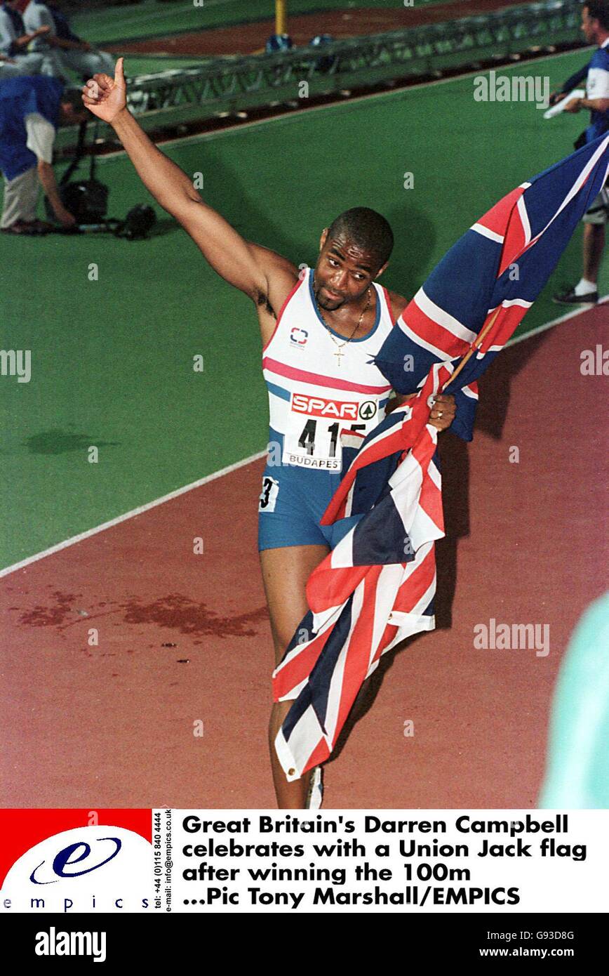 Darren Campbell della Gran Bretagna celebra con una bandiera di Union Jack dopo aver vinto il 100m Foto Stock