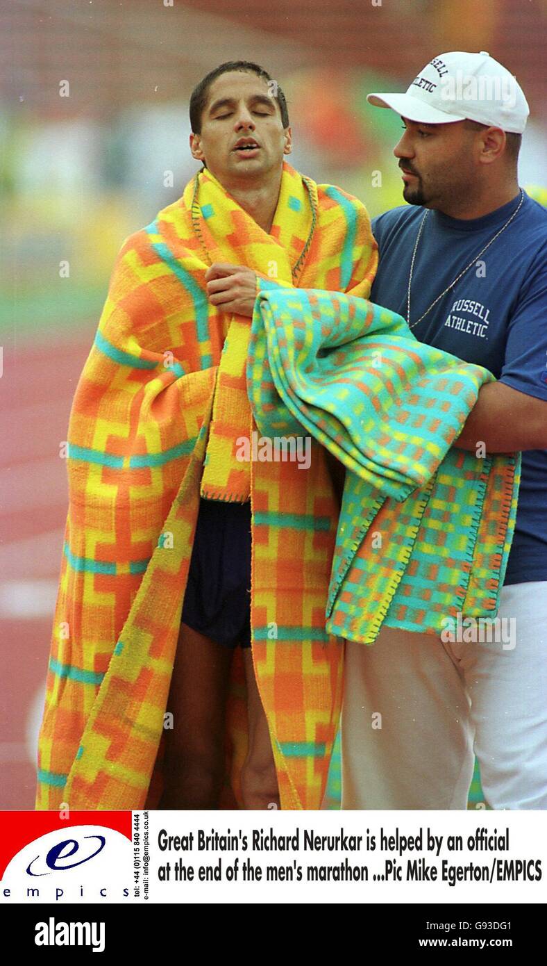 Richard Nerurkar della Gran Bretagna è aiutato da un ufficiale a. la fine della maratona maschile Foto Stock