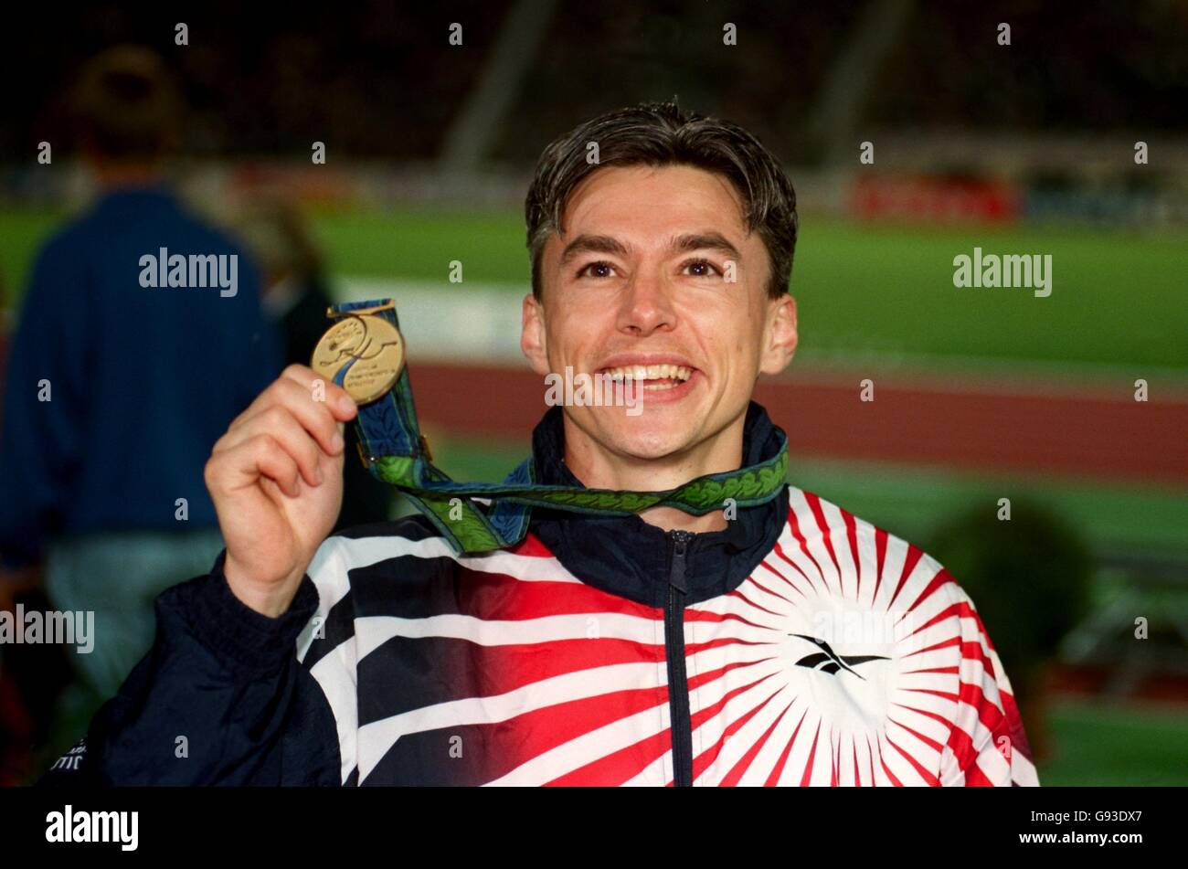 Jonathan Edwards della Gran Bretagna è tutti sorrisi dopo aver ricevuto il suo medaglia d'oro Foto Stock