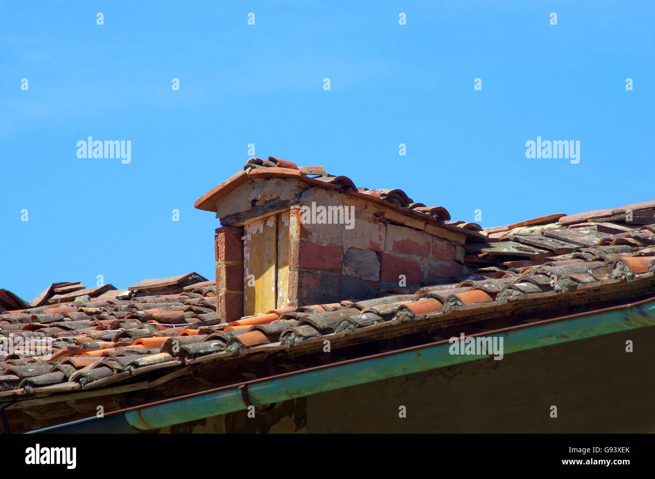 Mattone dormer e la vecchia porta di legno sulla tradizionale tetto con tegole del tetto Foto Stock