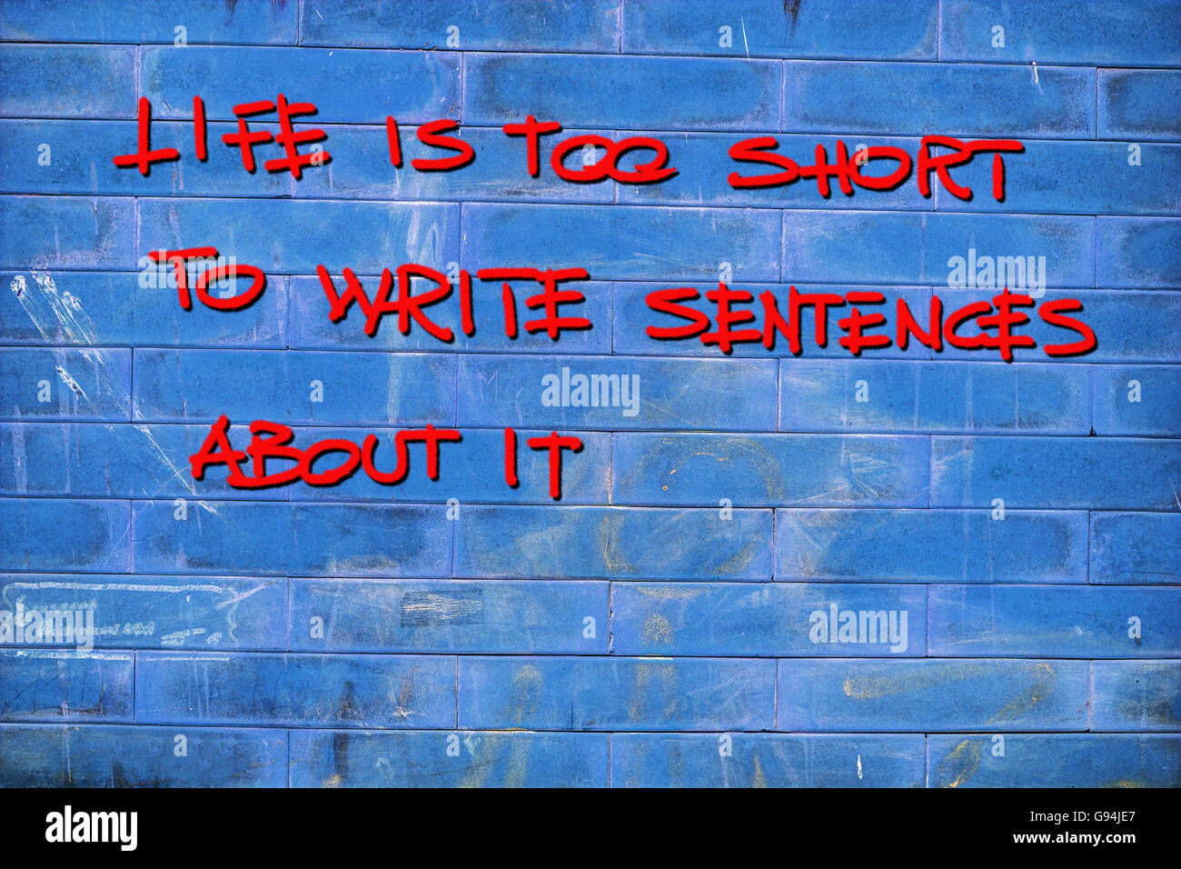 "La vita è troppo breve per scrivere frasi' scritto su una parete di colore blu Foto Stock