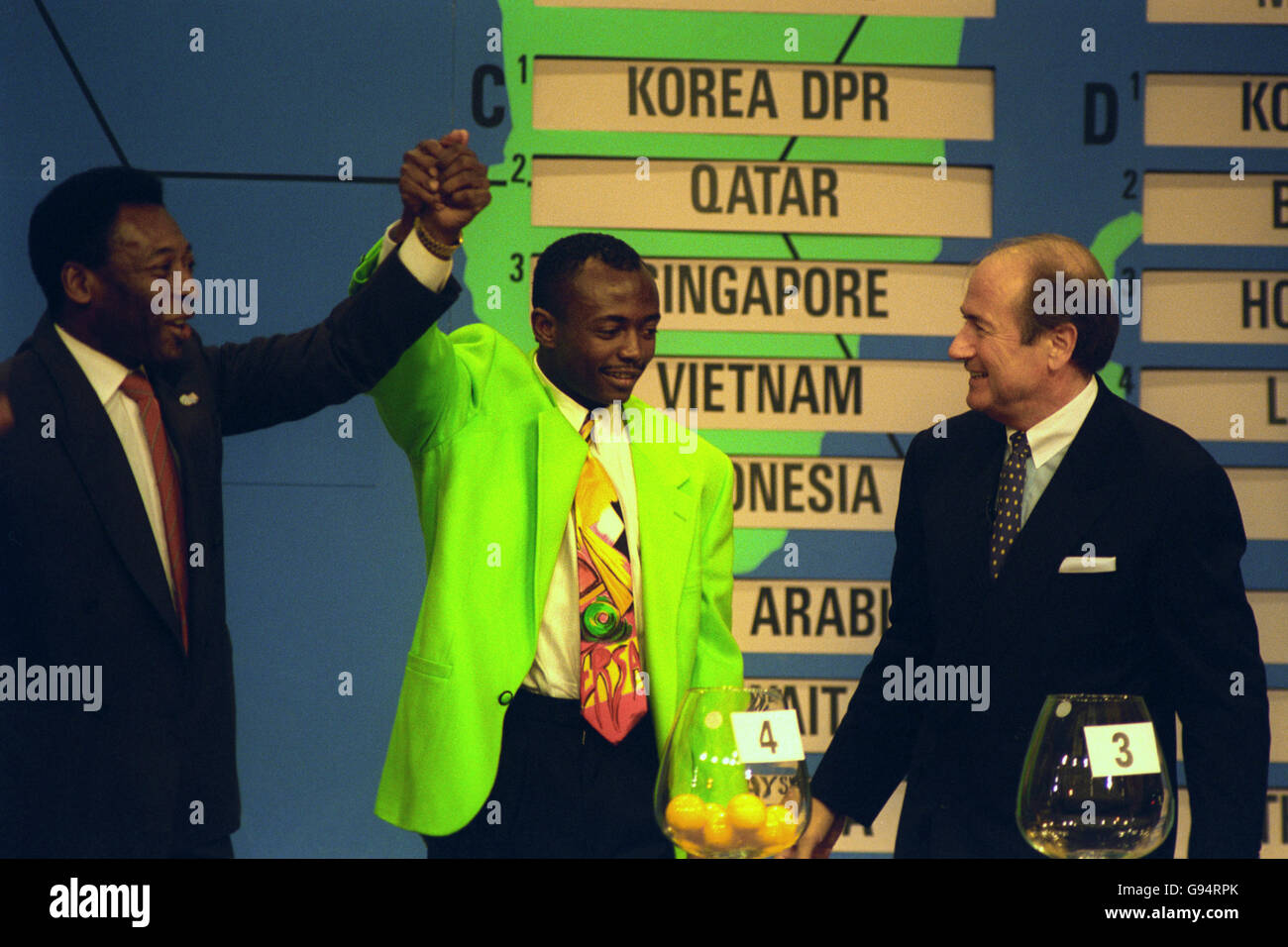 La superstar brasiliana Pele (l) alza il braccio di Abedi Pele (al centro) durante l'ultimo Campionato del mondo di qualificazione per la regione di Conmebol, che si è tenuto a New York, USA. Il Segretario Generale Sepp Blatter (r) si occupa. Foto Stock