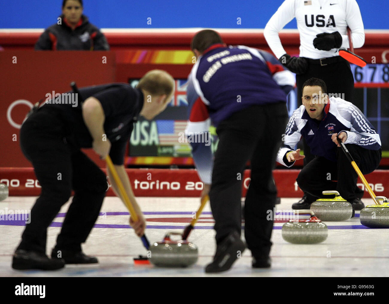David Murdoch (R) della Gran Bretagna guarda ai compagni di squadra Ewan MacDonald (L) e Euan Byers durante la gara di curling maschile contro gli Stati Uniti alle Olimpiadi invernali di Pinerolo Palaghiaccio, Italia, domenica 19 febbraio 2006. Vedere la storia della PA OLIMPIADI invernali. PREMERE ASSOCIAZIONE foto. Il credito fotografico dovrebbe essere: Andrew Milligan/PA. Foto Stock