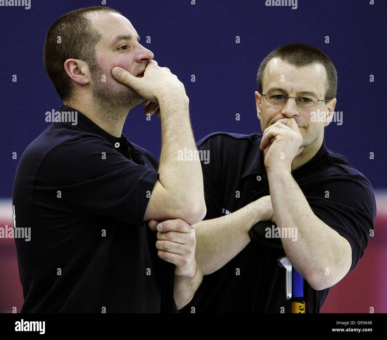 Euan Byers (L) della Gran Bretagna e Warwick Smith in profonda riflessione durante la gara di curling maschile contro gli Stati Uniti alle Olimpiadi invernali di Pinerolo Palaghiaccio, Italia, domenica 19 febbraio 2006. Vedere la storia della PA OLIMPIADI invernali. PREMERE ASSOCIAZIONE foto. Il credito fotografico dovrebbe essere: Andrew Milligan/PA. Foto Stock