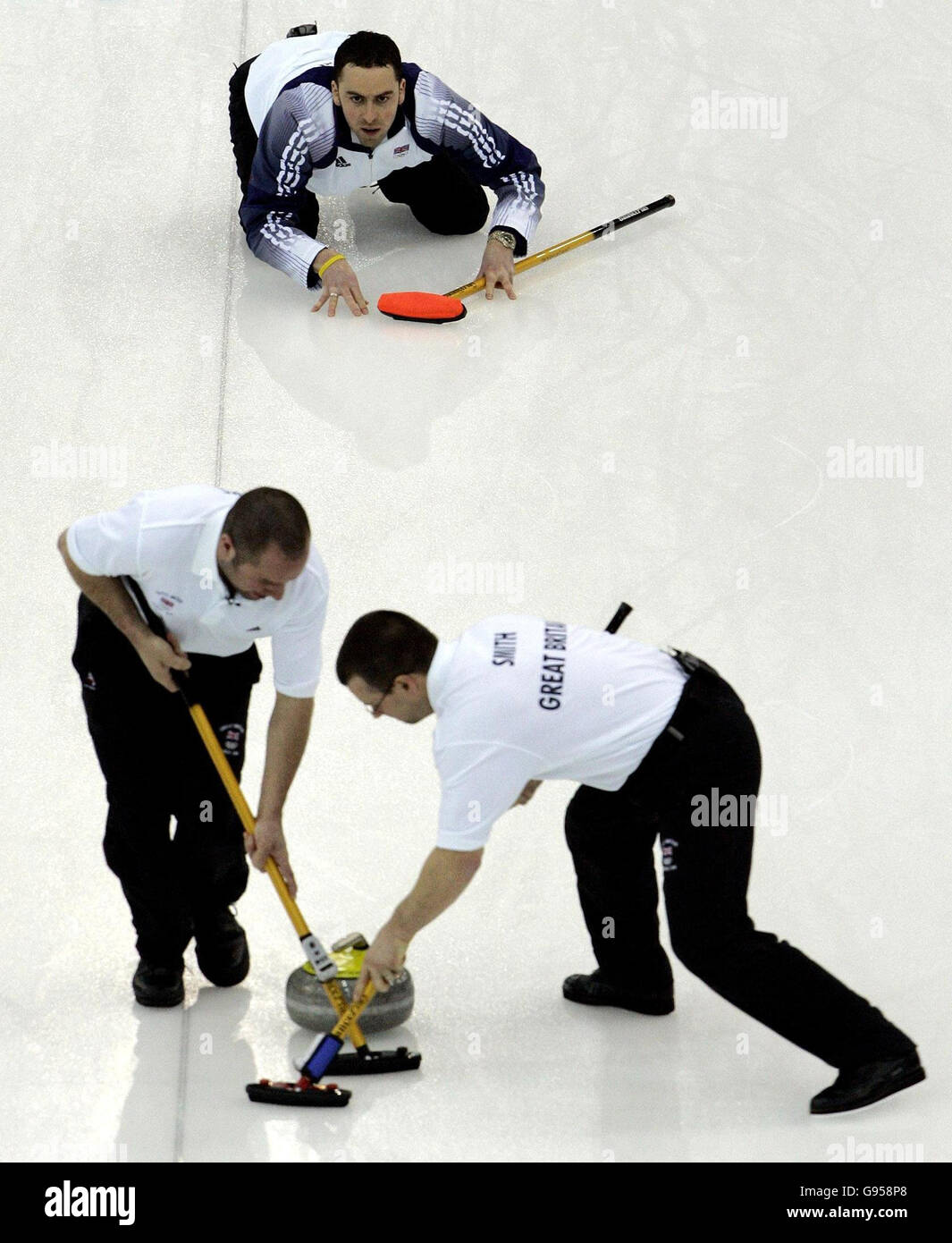 La squadra di curling Mens della Gran Bretagna di David Murdoch (TOP), Euan Byers (L) e Warwick Smith in azione durante la medaglia di bronzo curling maschile contro gli USA alle Olimpiadi invernali di Pinerolo Palaghiaccio, Italia, venerdì 24 febbraio 2006. Guarda la storia della Pennsylvania OLIMPIADI invernali. PREMERE ASSOCIAZIONE foto. Il credito fotografico dovrebbe essere: Andrew Milligan/PA. **SOLO PER USO EDITORIALE** Foto Stock