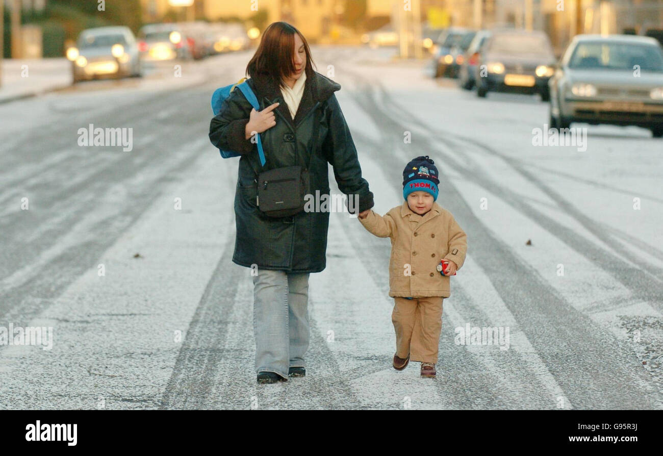 Rachel Newman cammina il figlio di due anni Liam James al vivaio attraverso la neve su Northinch Street a Glasgow, martedì 28 febbraio 2006. Un'esplosione artica ha attraversato oggi la Gran Bretagna con un diluvio di neve nelle parti settentrionali della Scozia e dell'Inghilterra. Blizzards colpì la Scozia settentrionale durante la notte, mentre la neve pesante cadde in alcune parti dell'Inghilterra settentrionale e orientale, in particolare nello Yorkshire e nel Lincolnshire. Vedere PA storia METEO neve. PREMERE ASSOCIAZIONE foto. Il credito fotografico dovrebbe essere: Danny Lawson/PA. Foto Stock
