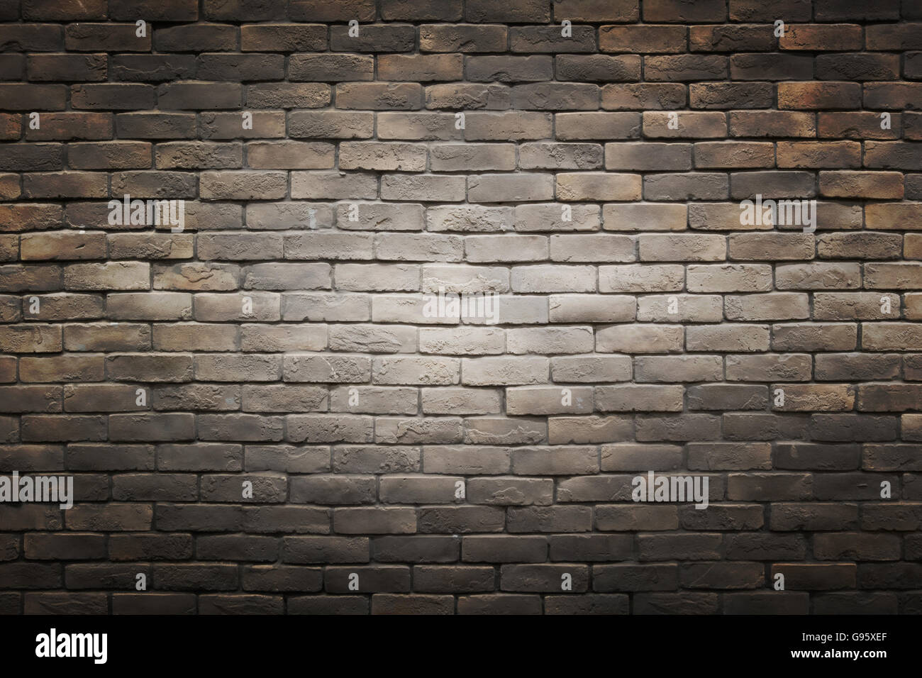 Nero scuro Grigio marrone un muro di mattoni con uno sfondo con gradiente di luce cerchio al centro Foto Stock