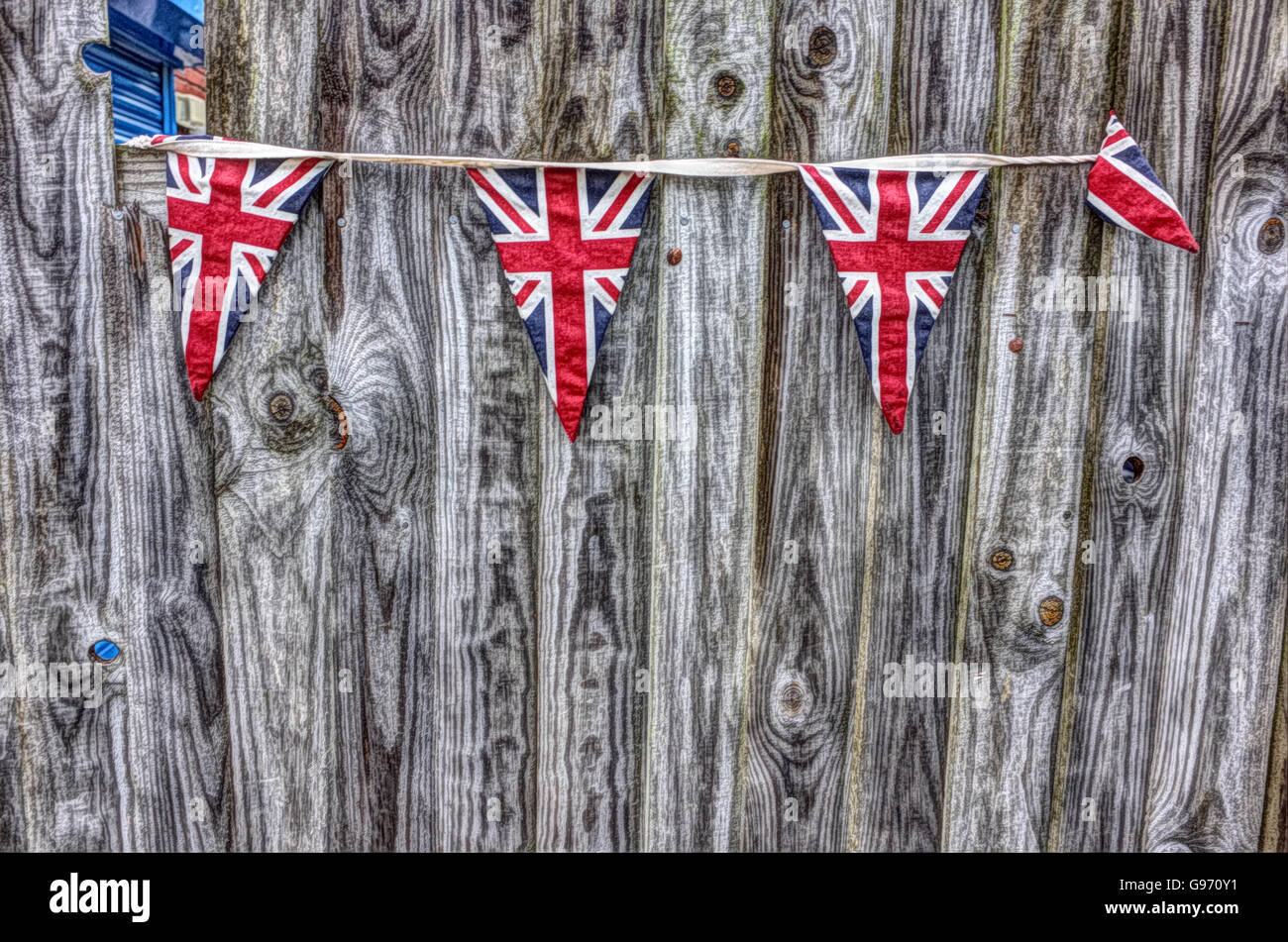 Unione Jack bunting contro il grigio di una recinzione con pannelli Foto Stock