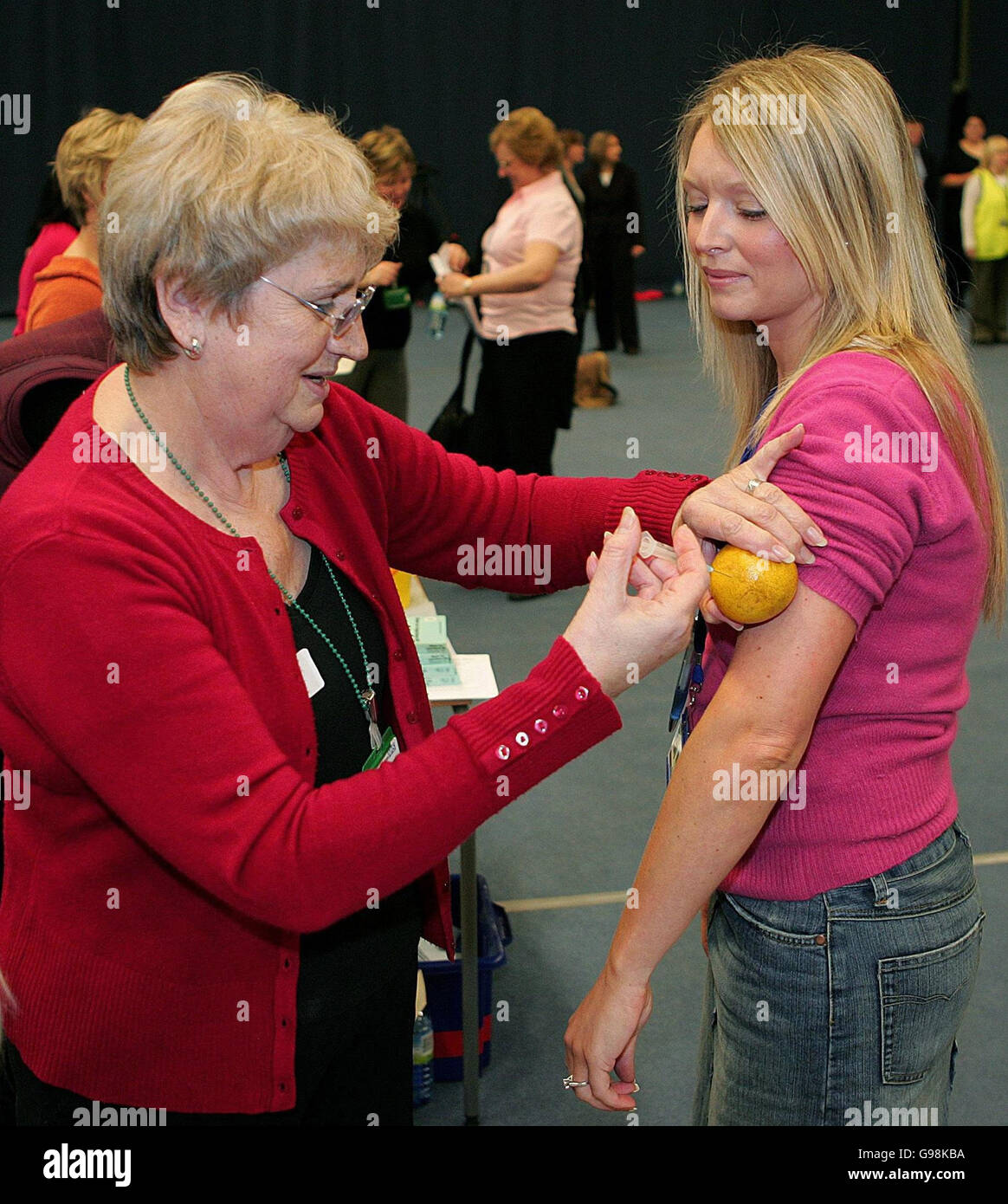 Un'infermiera inietta un'arancia durante un'esercitazione di immunizzazione di massa alla Bolton Arena, mercoledì 29 marzo 2006. Centinaia di persone hanno partecipato all'esercizio di oggi per testare le procedure per una vaccinazione di massa del pubblico in caso di pandemia influenzale. Vedere PA storia VACCINAZIONE SANITARIA. PREMERE ASSOCIAZIONE foto. Il credito fotografico dovrebbe essere: Martin Rickett/PA. Foto Stock