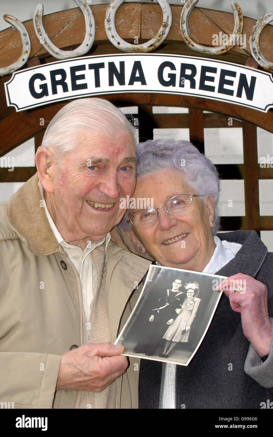 Coppia di nozze di diamante Ronald Woodard 84 e Muriel Woodard 83 con una fotografia dal loro giorno di nozze in 1956, a Gretna Green Mercoledì 5 aprile 2006. 25 coppie che celebrano il loro anniversario di matrimonio Diamante e dorato si sono recate a Gretna Green per essere benedette sopra l'incudine originale nel famoso negozio di fabbri, tra loro costituiscono 1250 anni di vita sposata. Guarda Gretna STORIA SOCIALE PA. PREMERE ASSOCIAZIONE FOTO. IL CREDITO FOTOGRAFICO DOVREBBE ESSERE DANNY Lawson /PA Foto Stock