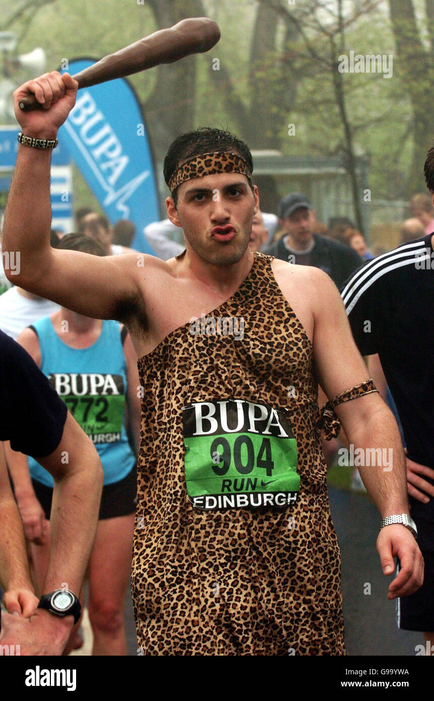 Un corridore senza nome vestito come caveman compete nella corsa grande di Edinburgo di BUPA. Foto Stock