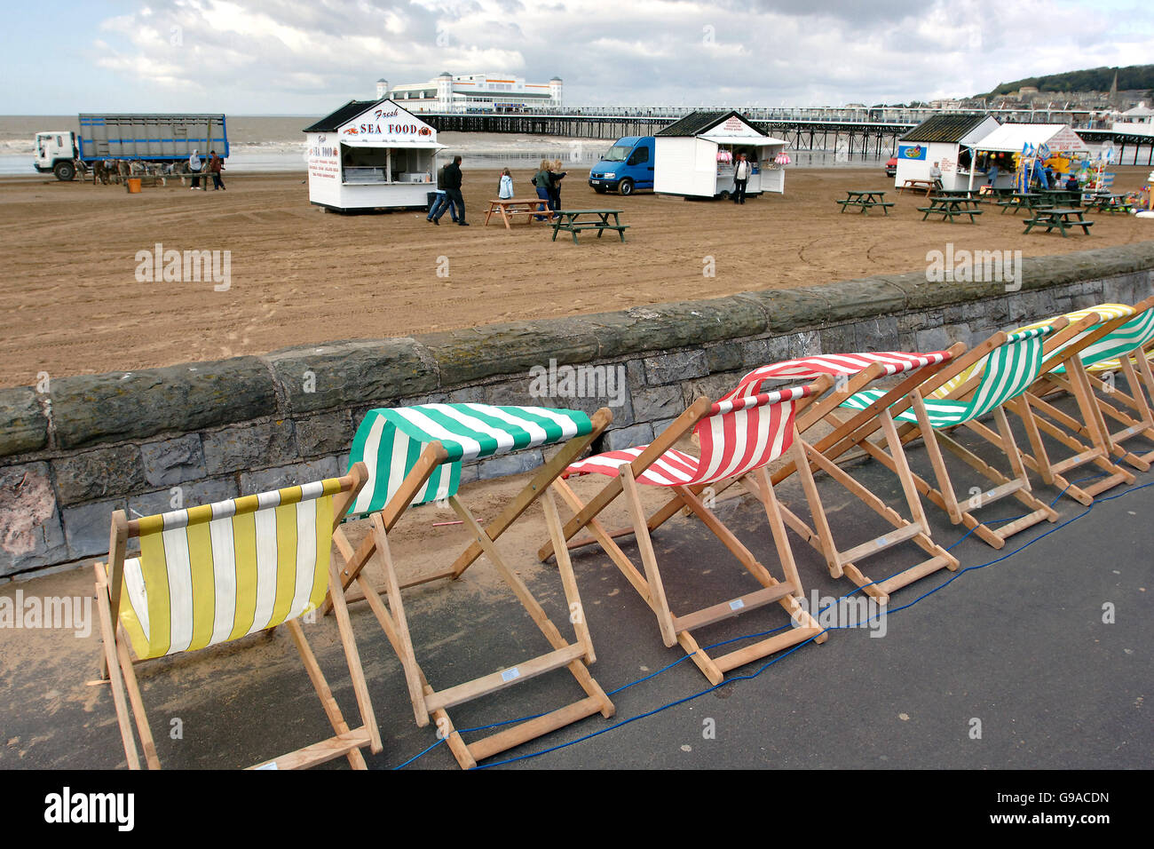 Bank Holiday Winds buffet le sedie a sdraio sul fronte mare a Weston-super-Mare in Somerset. Foto Stock