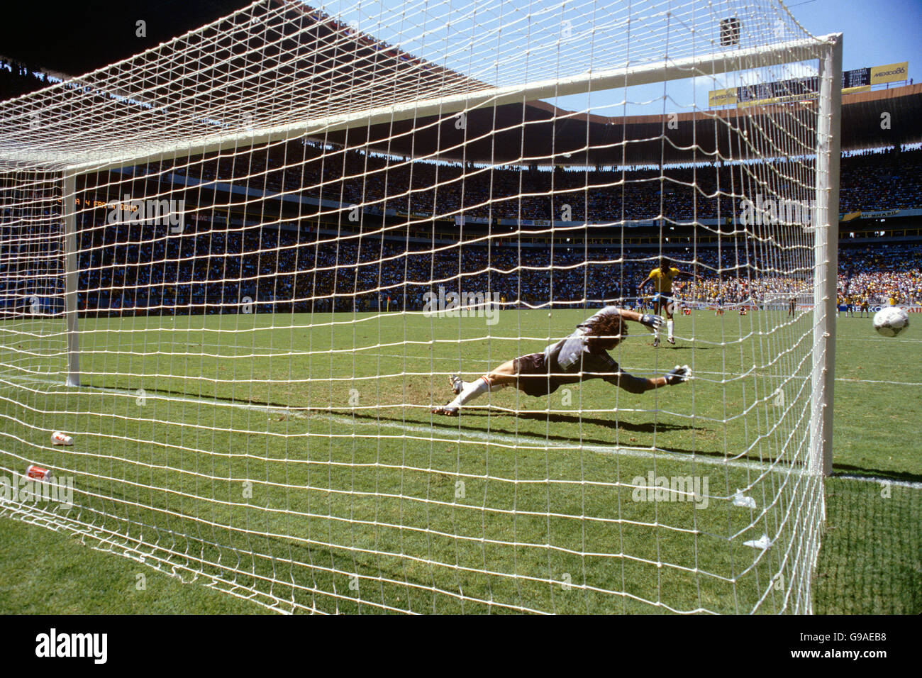 Il brasiliano Julio Cesar guarda la sua pena ha colpito il post e. Volate di nuovo fuori mentre il portiere francese Joel Bats si tuffa giusto Foto Stock