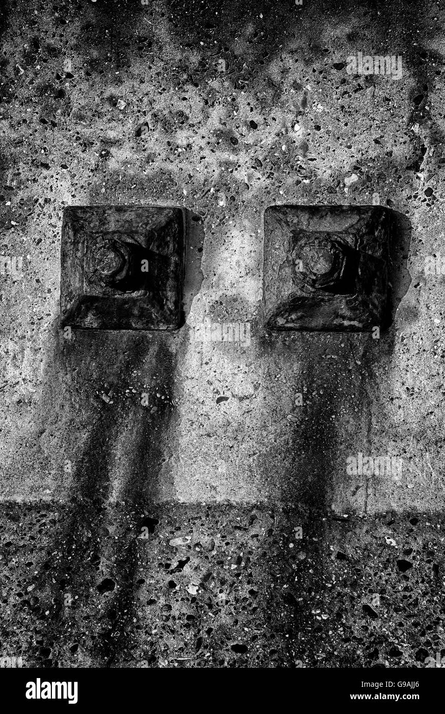 Arrugginimento bulloni in un mare di cemento muro di difesa, Aldeburgh, Suffolk, Inghilterra Foto Stock