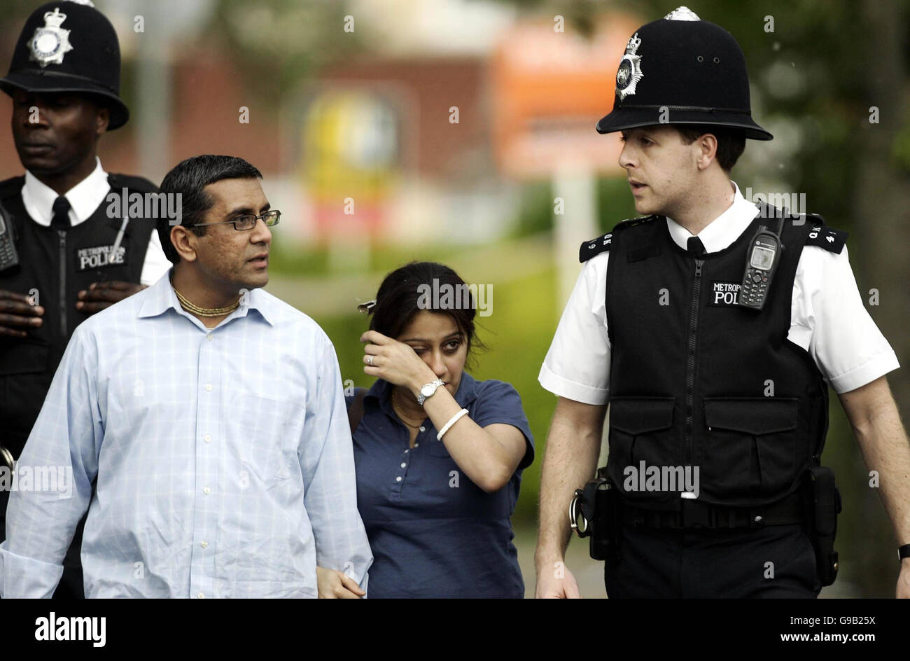 Una donna con il suo partner che tiene i fiori di Sudbury Avenue, Wembley dopo Special Constable Nisha Patel-Nasri fu assassinato in strada al di fuori di casa sua. Foto Stock
