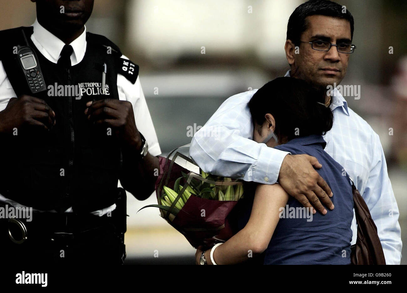 Una donna con il suo partner che tiene i fiori di Sudbury Avenue, Wembley dopo Special Constable Nisha Patel-Nasri fu assassinato in strada al di fuori di casa sua. Foto Stock