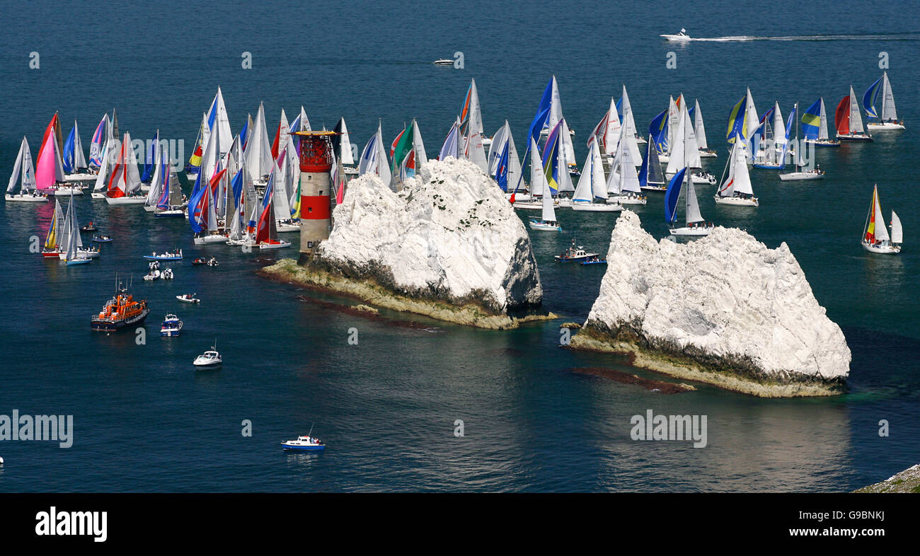 I concorrenti che corrono nel 75° Round The Island Race si radunano al faro Needles sulla punta occidentale dell'isola di Wight mentre i venti cadono. Foto Stock