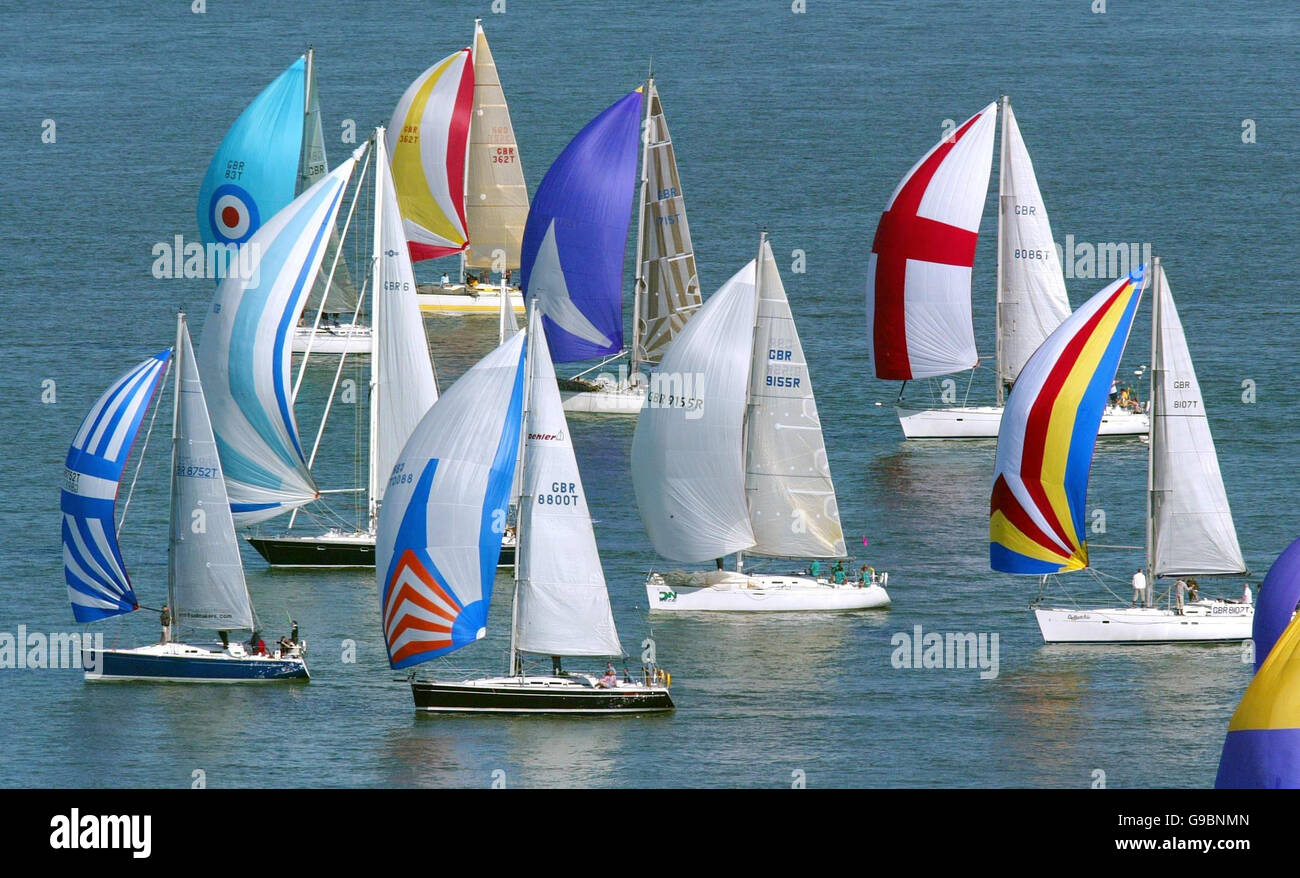 I concorrenti che corrono nel 75° round The Island Race volano i loro spinnaker, tra cui uno con una croce di San Giorgio, come passare attraverso l'Hurst Narrows nel solente occidentale. Foto Stock