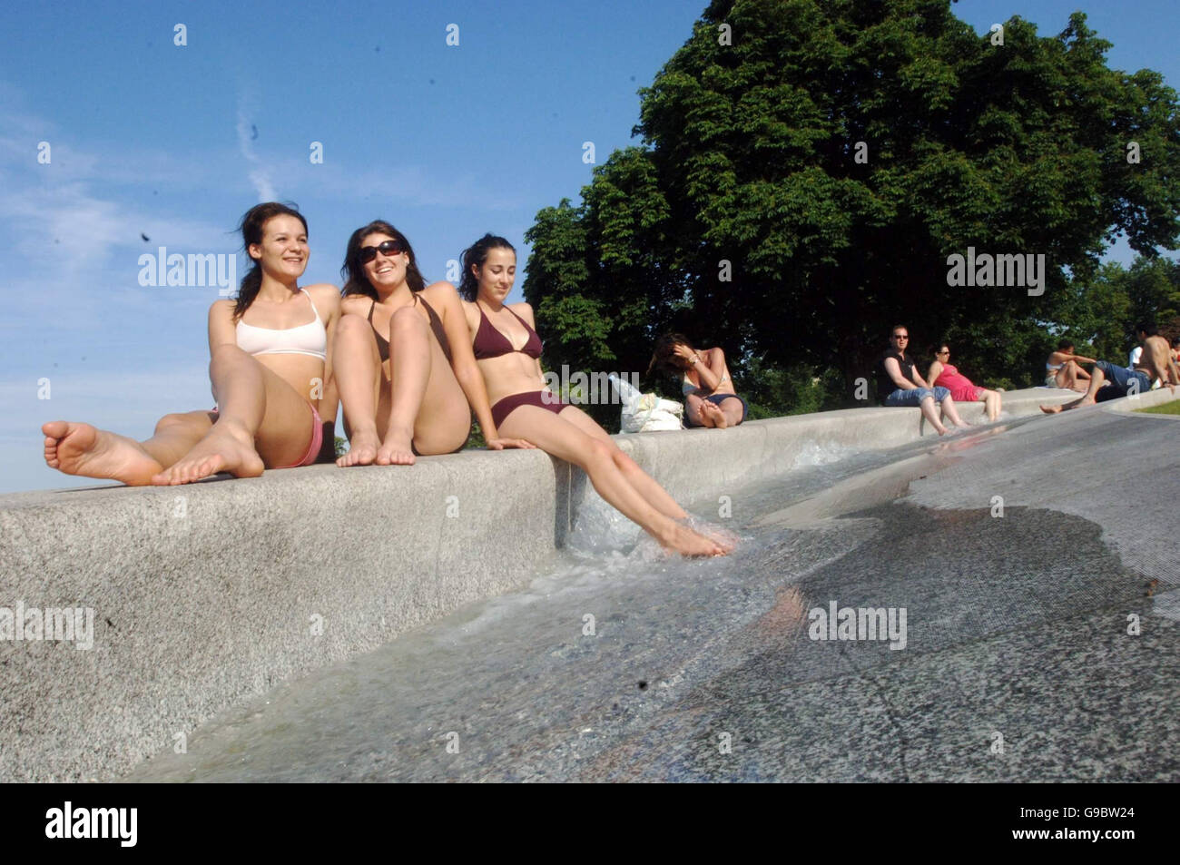 Da sinistra a destra: Studenti Charlotte Macke (19) Holly Keepfer (19) e Shireen Shomaly (20) tutti da East London godetevi il sole di Diana Memorial fontana in Hyde Park. Foto Stock