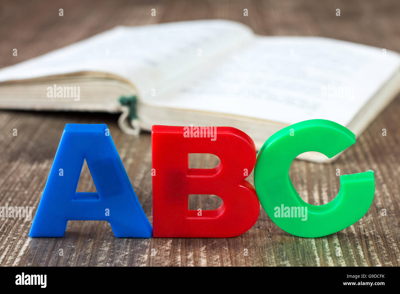 ABC di ortografia e libro aperto su sfondo di legno Foto Stock