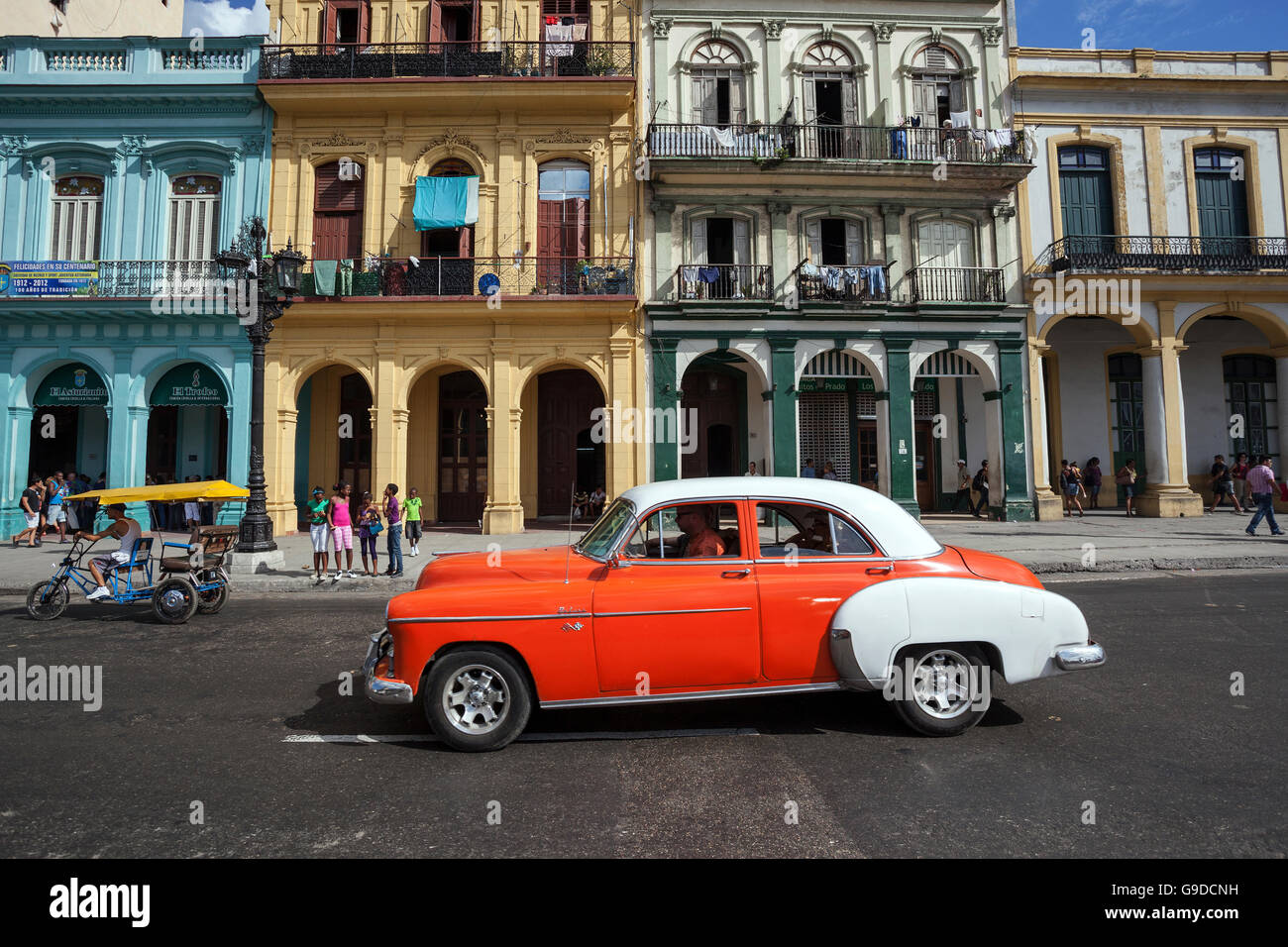 Scenario di strada, arancione e bianco auto d'epoca, di fronte facciata colorata presso il Museo del Prado, il centro storico, l'Avana, Cuba Foto Stock