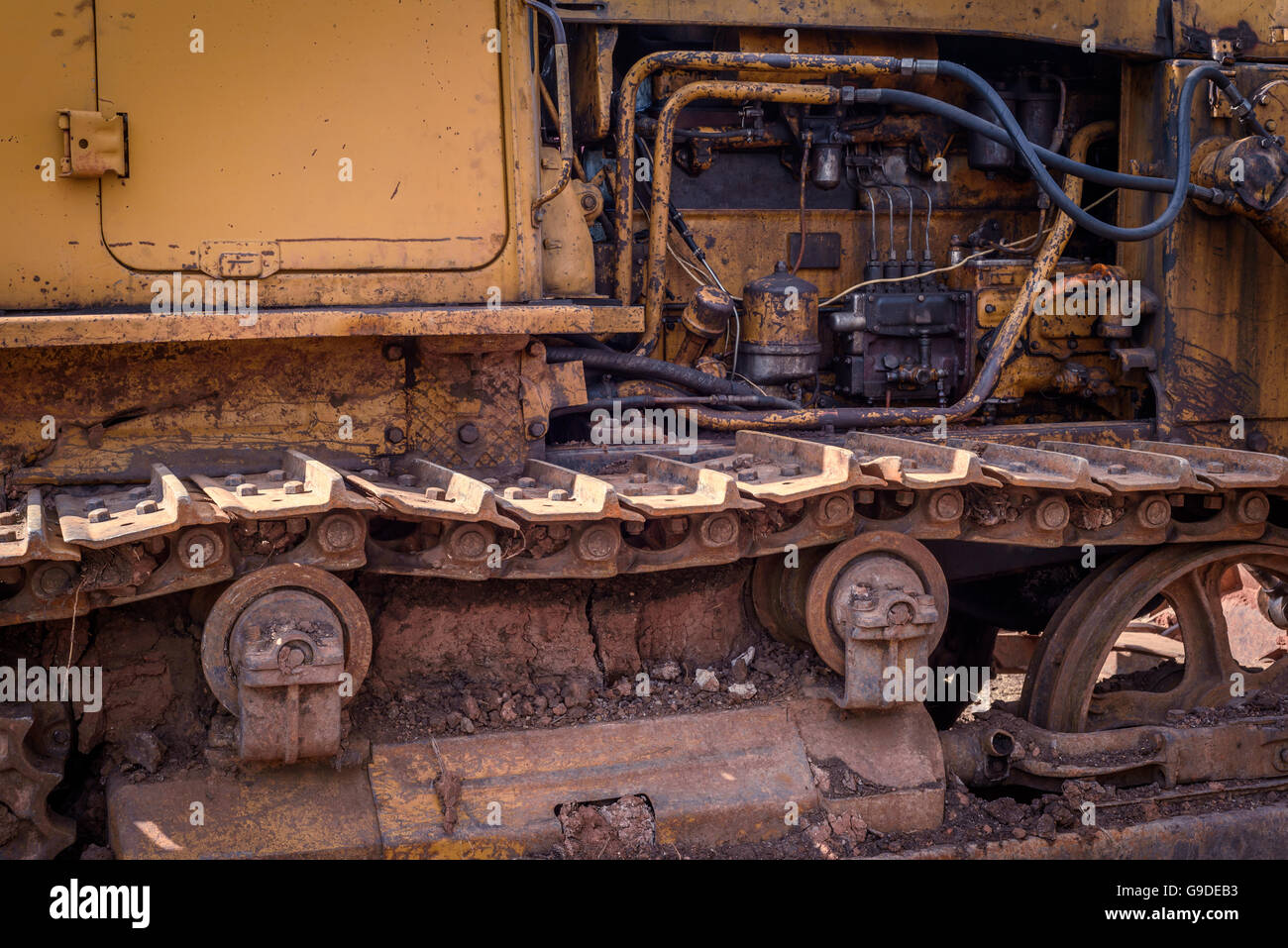 Età industriale abbandonato la macchina con lo sporco corrosi colorate cingoli e ruote dentate. Foto Stock