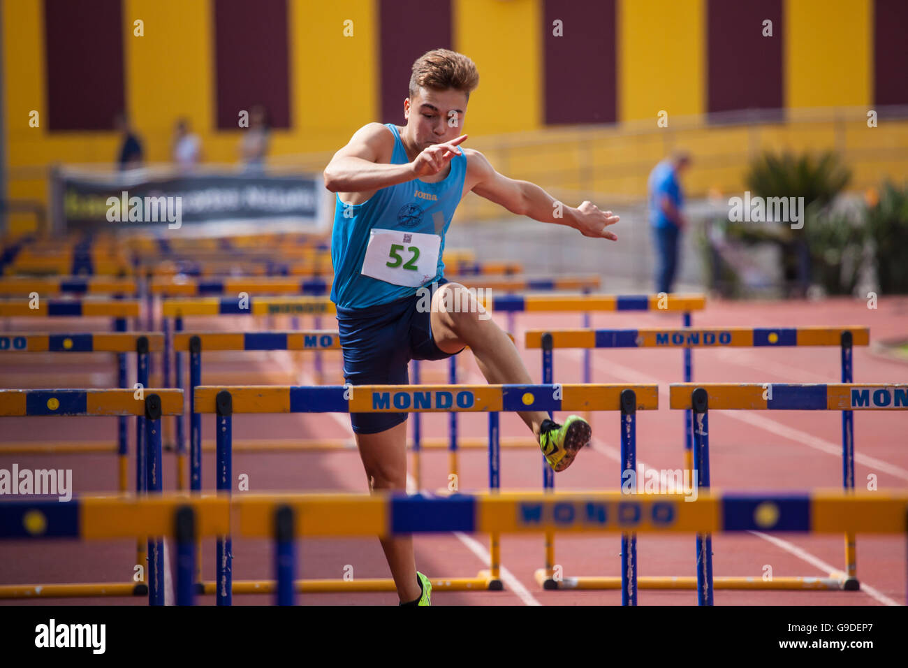 Sport ragazzo facendo Hurdling su una pista di atletica Foto Stock