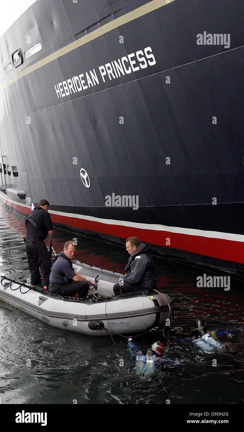 I sommozzatori di polizia effettuano controlli di sicurezza sulla principessa Ebridea a Port Ellen, prima che la famiglia reale salti a bordo della nave per una crociera di una settimana intorno alle isole occidentali come parte delle celebrazioni degli 80 anni della Regina. Foto Stock