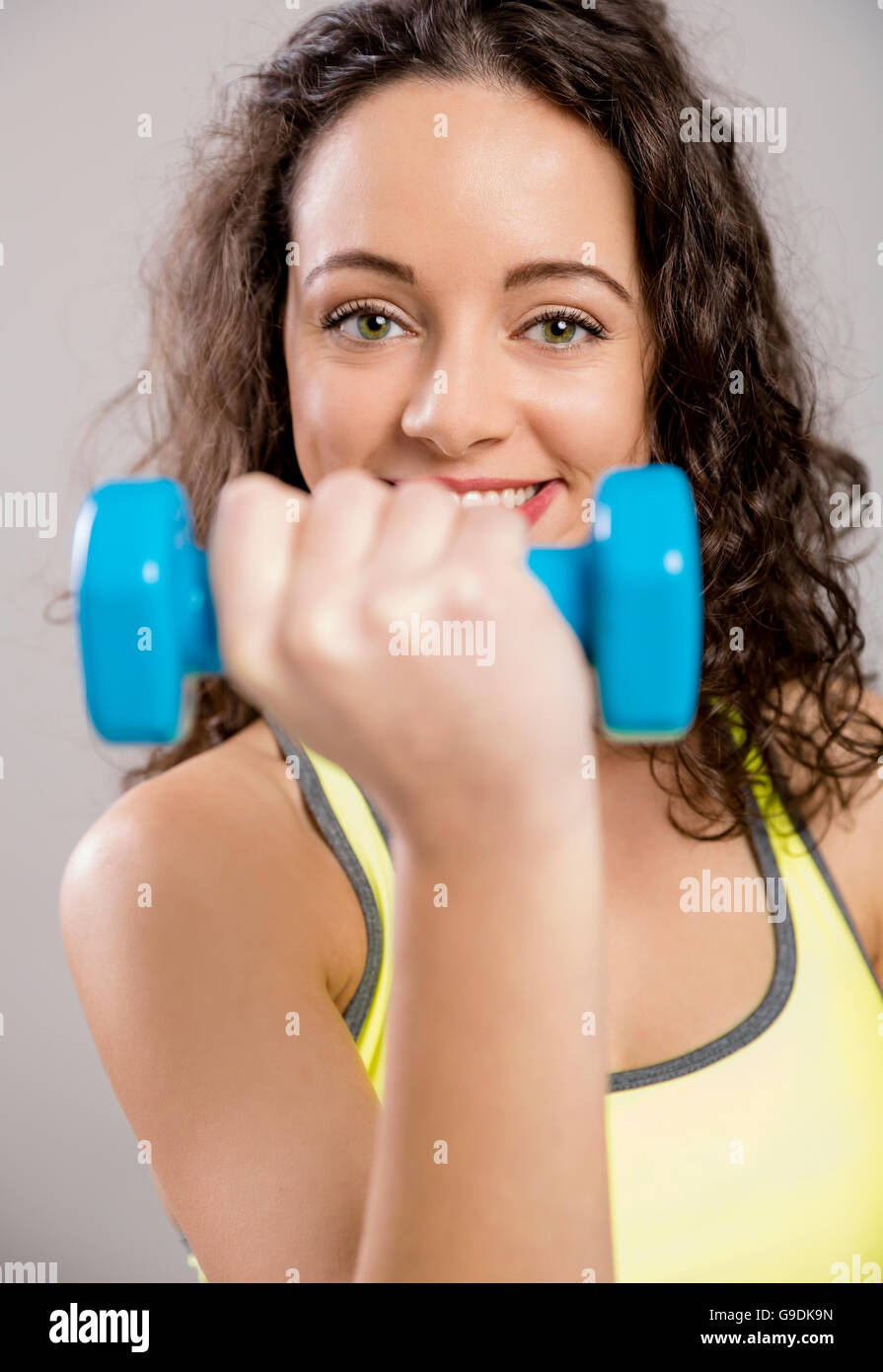 Bella donna sportivo facendo esercizi con pesi Foto Stock