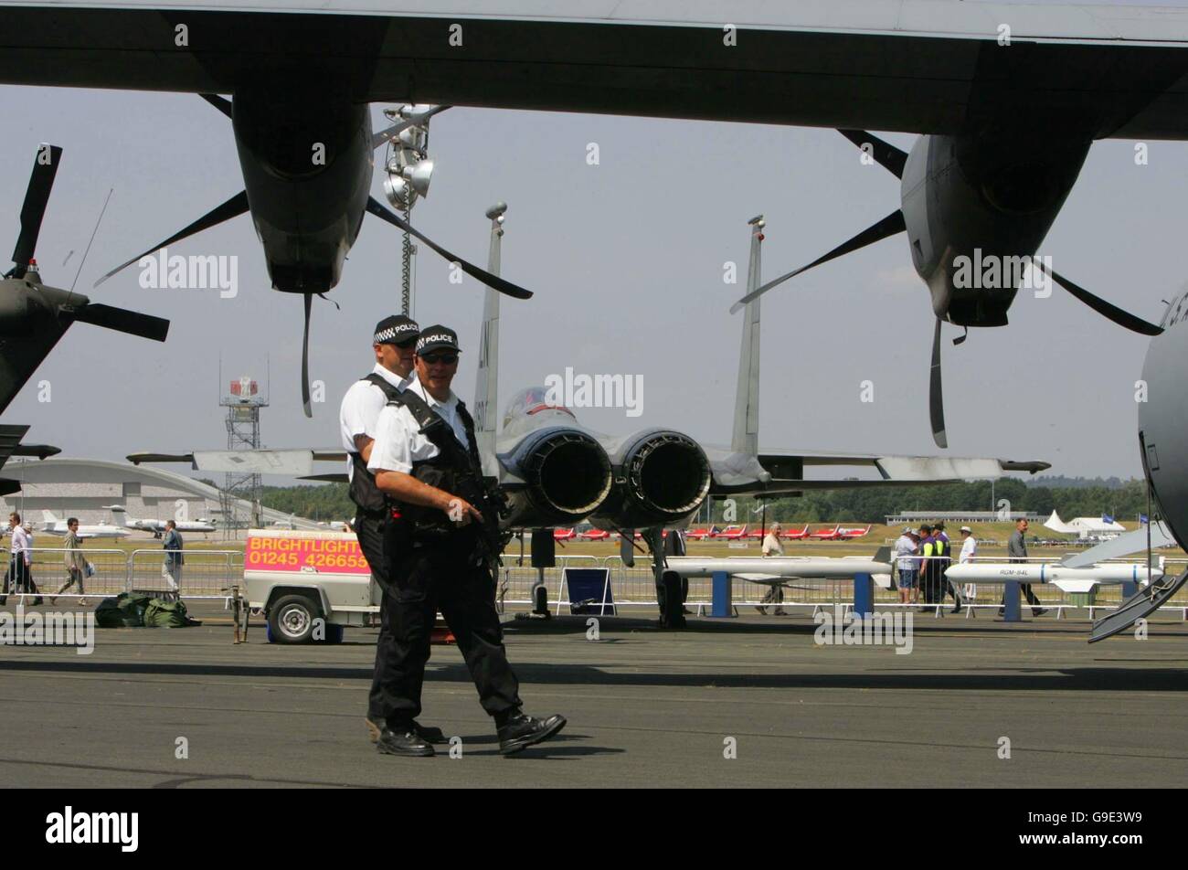 La polizia armata custodiscia l'esposizione di aerei statici al Farnborough International Airshow nell'Hampshire. Foto Stock