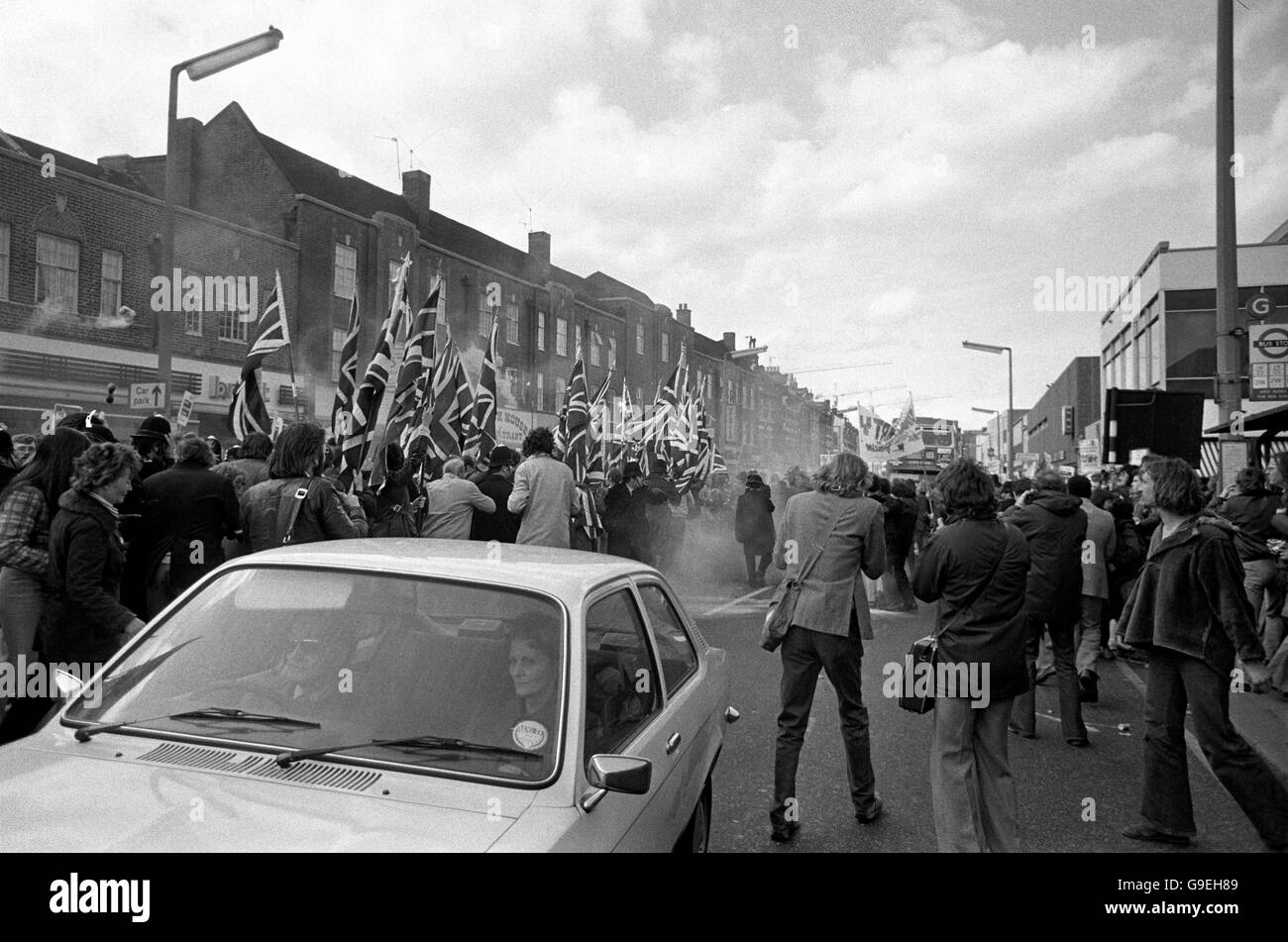 Una bomba di fumo esplode intorno a Union Jack che porta i sostenitori del fronte Nazionale nel Nord di Londra quando si scontrarono con le algerie di sinistra antifasciste. Foto Stock