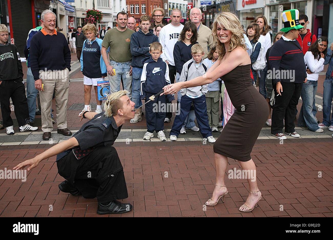 Top modello irlandese Jenny Lee rimuove una spada dalla bocca di un artista noto come Australian Space Cowboy, nel centro della città di Dublino, per lanciare la prima mai street performance nel campionato del mondo che si terrà il 5 agosto e il 6° al Merrion Square nella città. Foto Stock