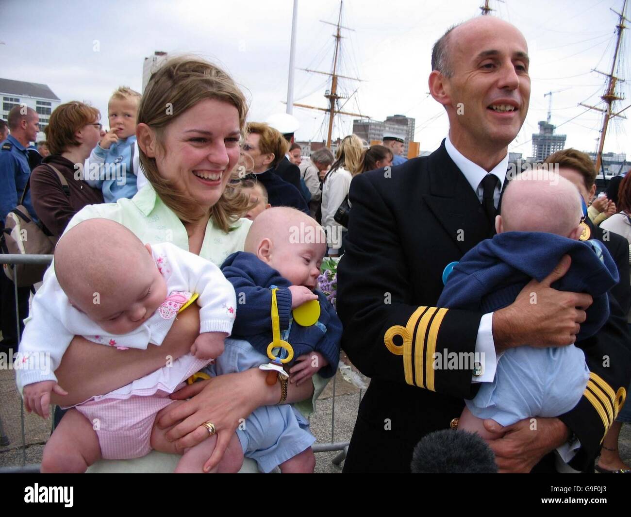 Mike Paterson, comandante dell'ufficiale della HMS Gloucester, è riunito con sua moglie, Anne, e i loro tripletti, George, Grace e Harry, Nato due settimane prima di lasciare Portsmouth all'inizio di aprile, le due navi da guerra della Royal Navy che hanno aiutato a evacuare 4,400 cittadini britannici dal Libano tornano oggi alla base. Foto Stock