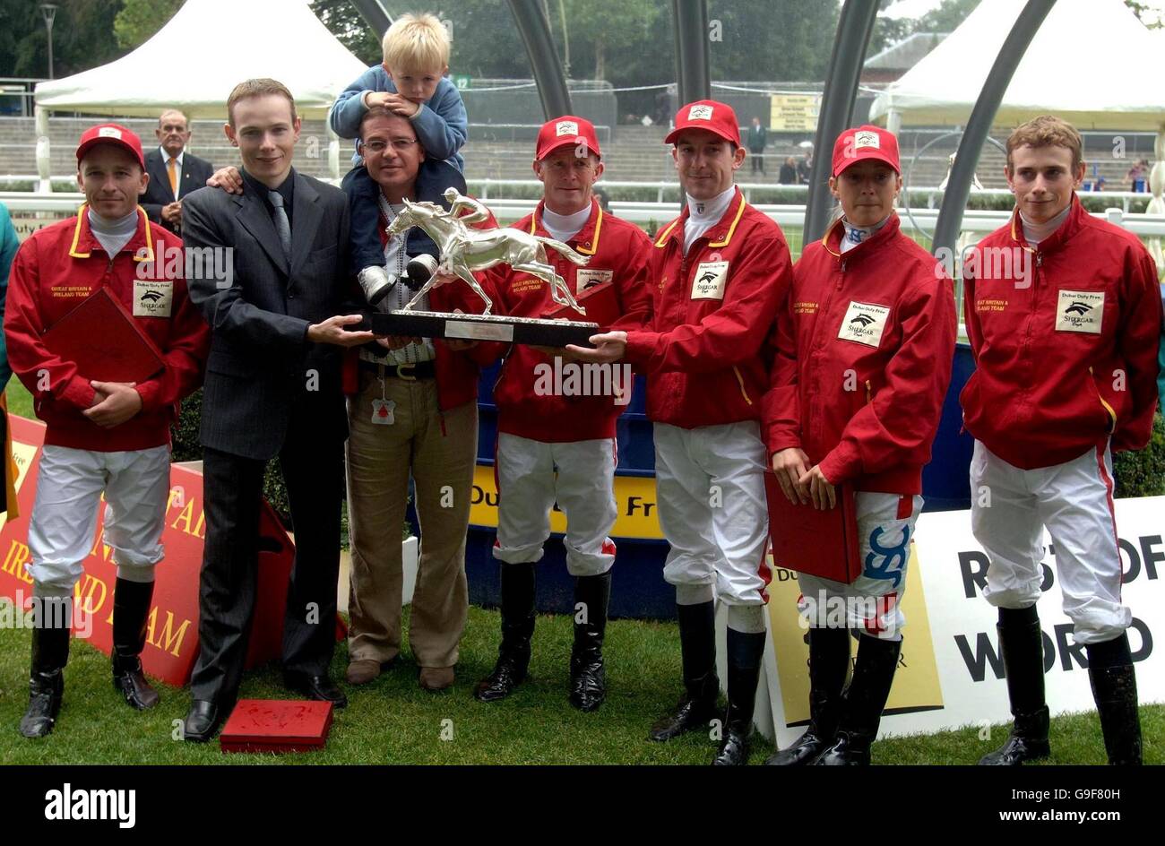 Il team manager Jason Weaver (terza a sinistra) con suo figlio Max e il capitano della squadra Jamie Spencer (seconda a sinistra) tiene il trofeo della Shergar Cup dopo aver vinto all'ippodromo di Ascot. Foto Stock