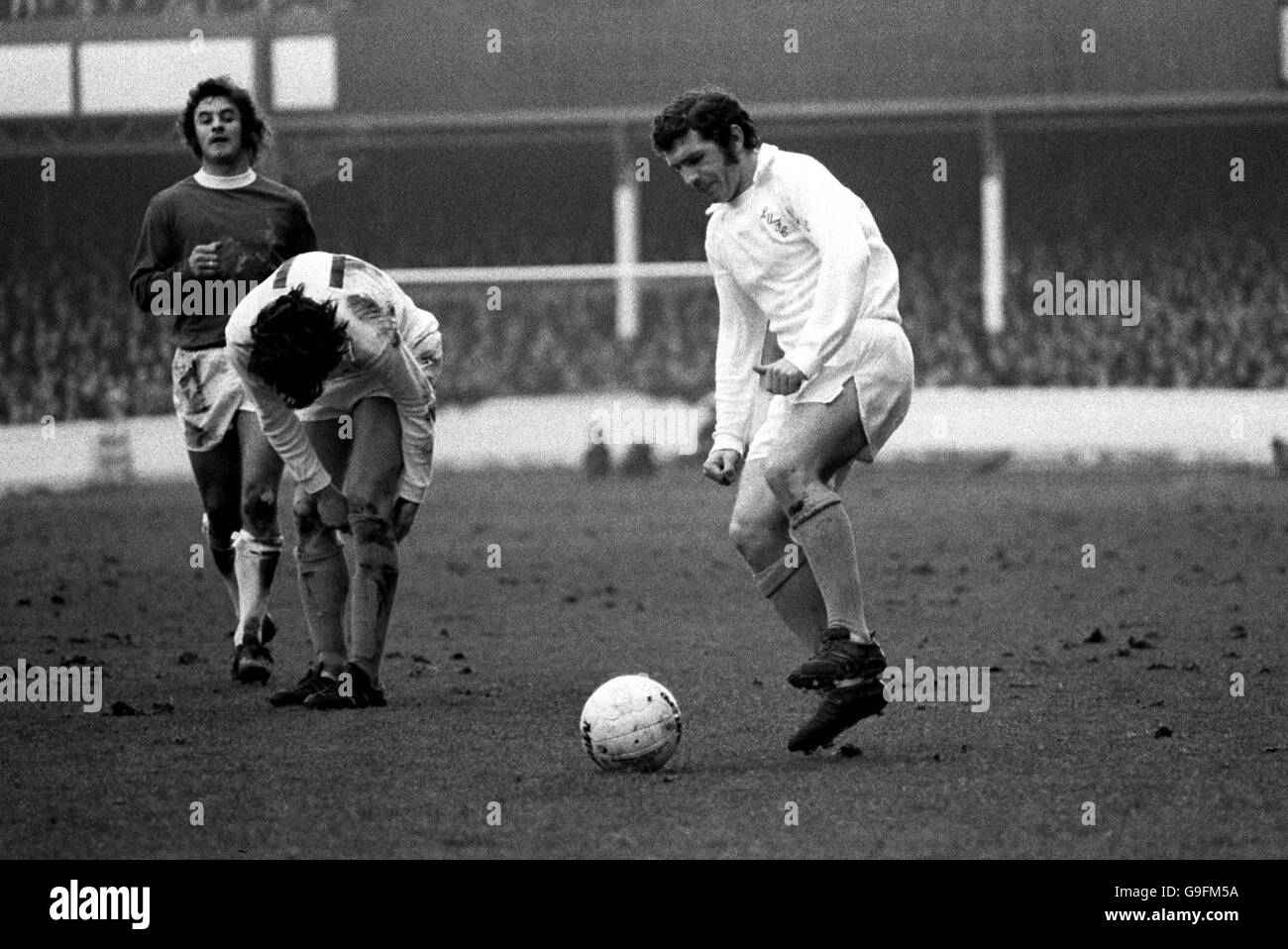 Johnny Giles di Leeds United (r) raccoglie il pallone mentre il compagno di squadra Eddie Gray (c) tira le calze, guardato da Jimmy Husband di Everton (l) Foto Stock