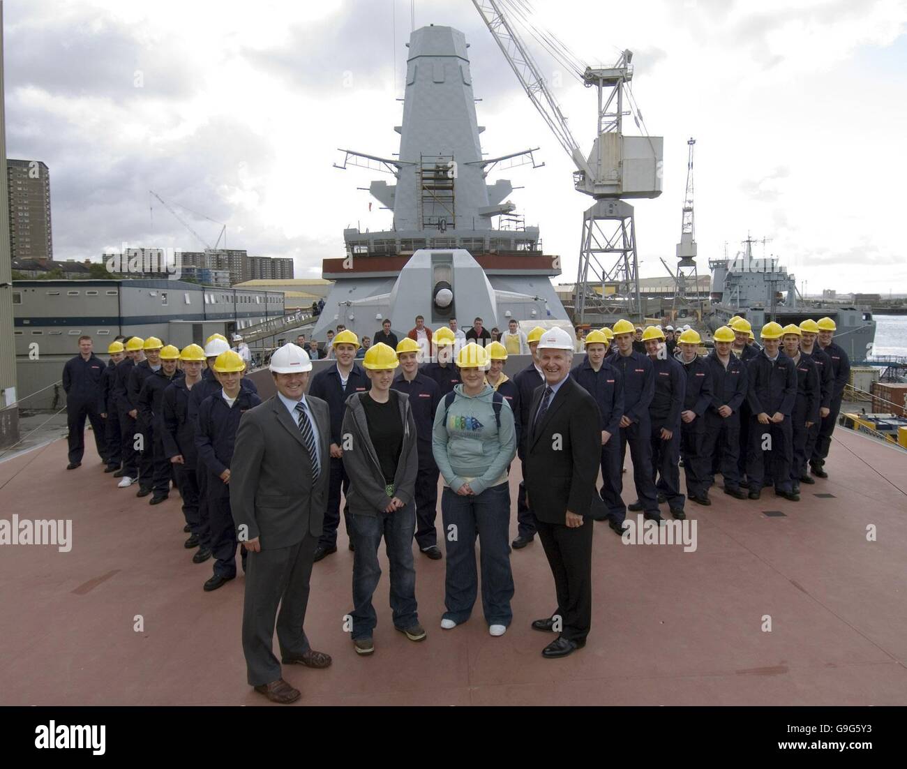 Molly Scott, 18 da Ibrox e Sarah Jane Allison 18 da East Kilbride con Vic Emery, BAE Systems navi militari, M.D. & Enterprise Ministro Alan Wilson. Essi sono due dei 70 nuovi apprendisti di girare per il loro primo giorno di lavoro sul BAE apprendistato presso il cantiere di Clyde, Glasgow. Foto Stock