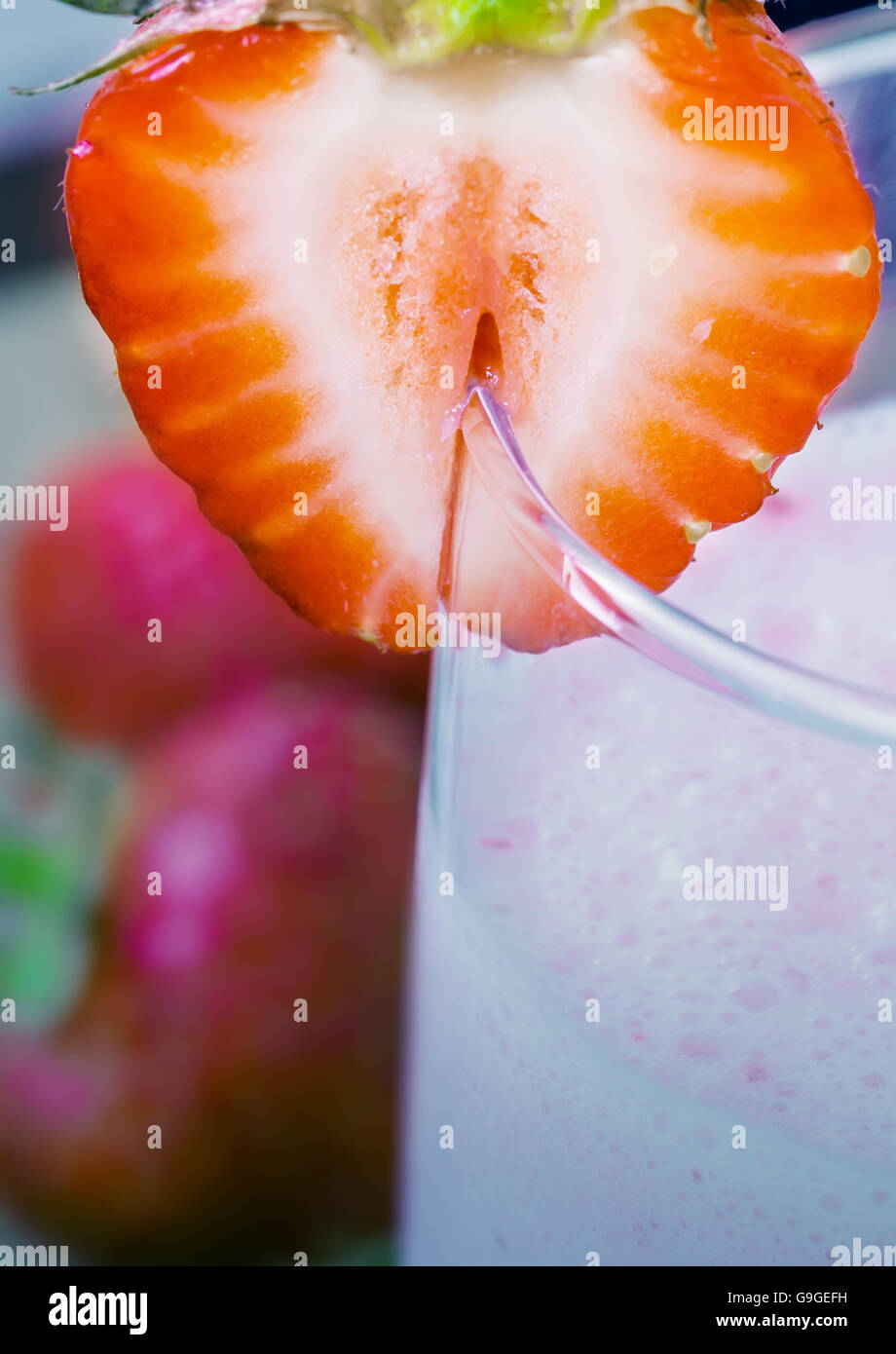 Milk shake alla fragola con fragole su sfondo di legno, soft focus su fragola sul vetro Foto Stock