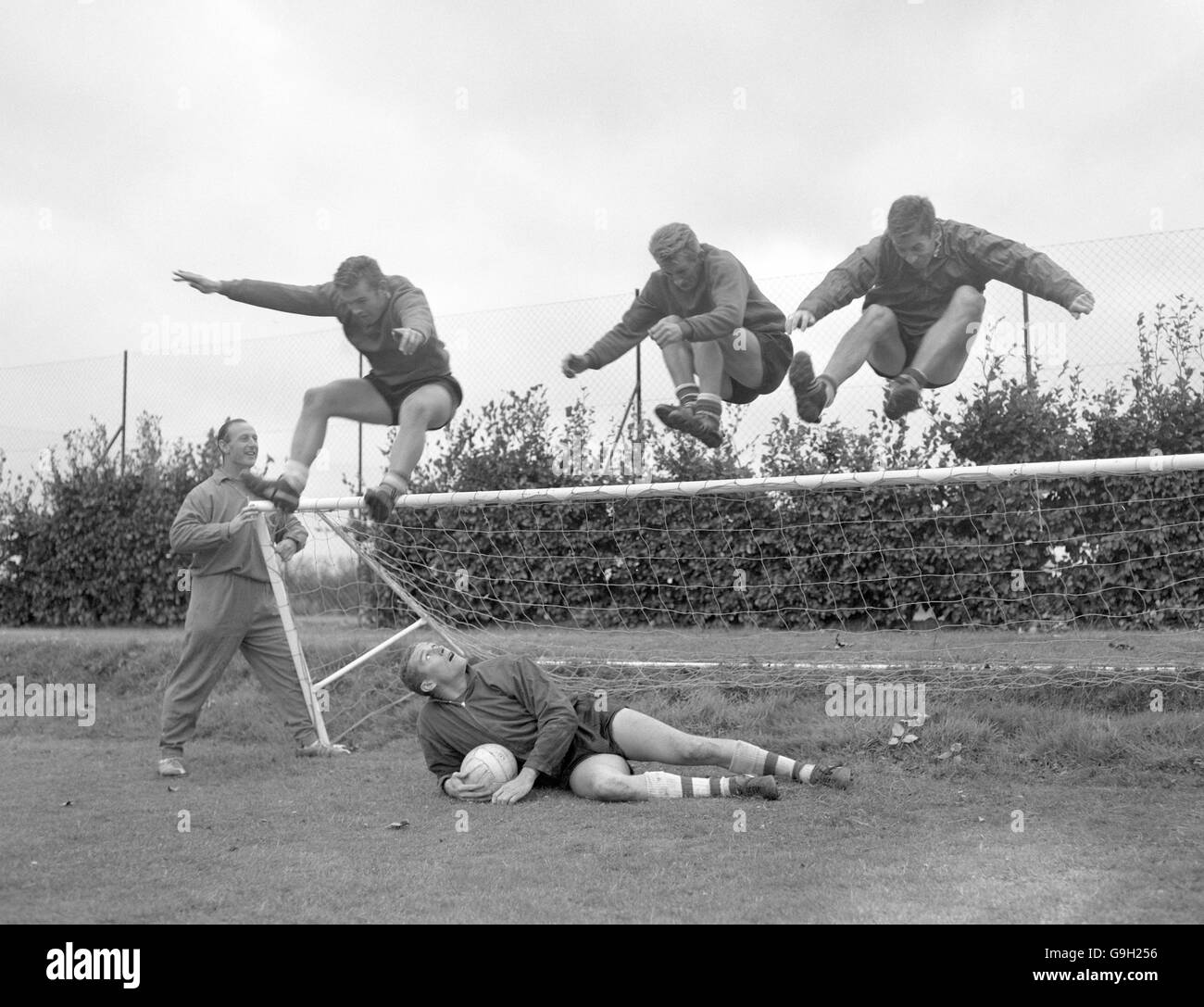 (L-R) l'allenatore dell'arsenale Bertie Mee tiene il traguardo come Joe Baker, George Eastham e Geoff salta forte sul portiere Jim Furnell (sul pavimento) Foto Stock