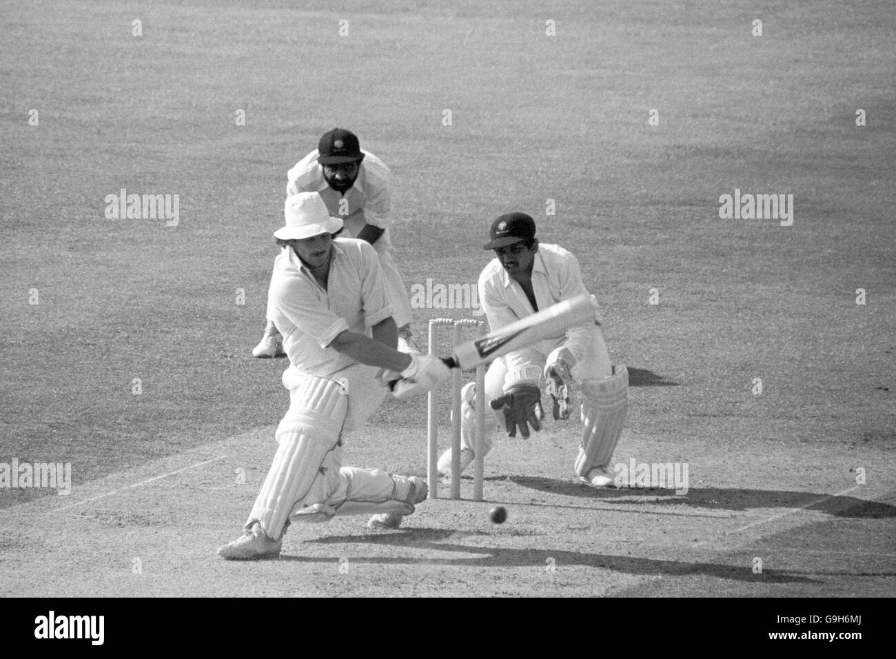 L'inglese Ian Botham (l) passa la palla al confine per completare il doppio test più veloce di 1000 corse e 100 wickets, dopo aver fatto solo 21 test per raggiungere l'impresa. Guardando sopra è India wicketkeeper Bharat Reddy (r) Foto Stock