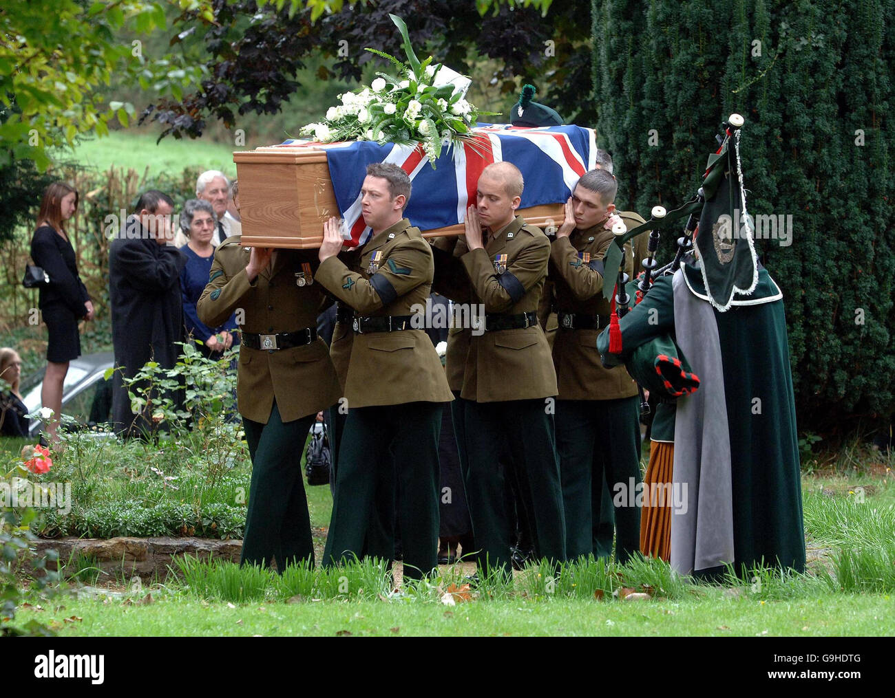 Un piper gioca il lamento regimentale come la bara contenente il corpo del caporale di lancia Paul Muirhead del 1 ° reggimento reale irlandese è portato in St. Mary la Vergine Chiesa, Bearley, Warwickshire, per il suo servizio funerale. Foto Stock