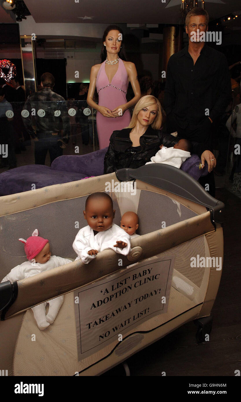 Una mostra a tema attorno al dibattito sull'adozione dei bambini delle celebrità, con i manichini Madonna, Brad Pitt e Angelina Jolie, al Madame Tussauds, nel centro di Londra. Foto Stock