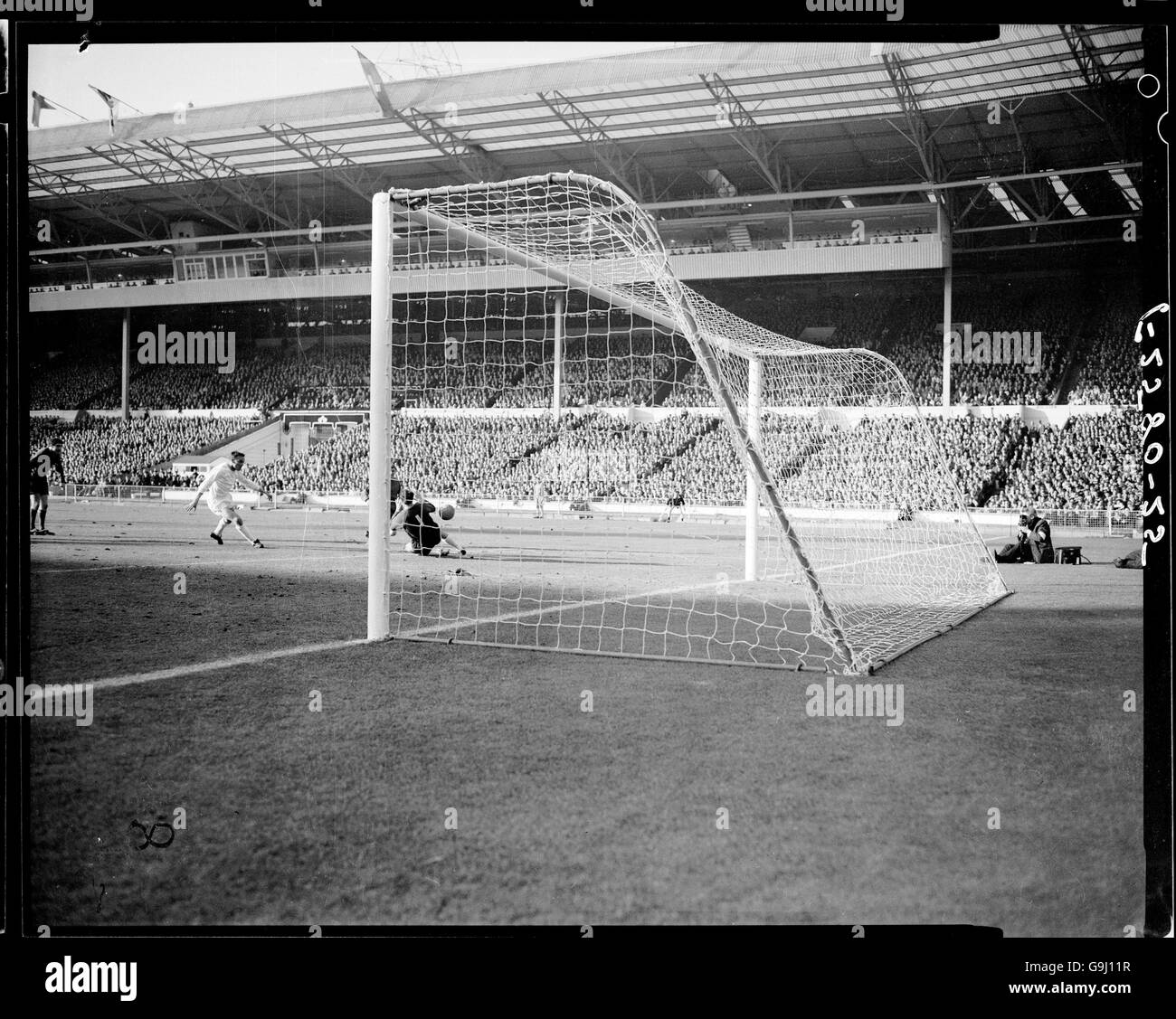 West Bromwich Albion's Clive Clark (dietro il post) passa la palla oltre il portiere dei Queens Park Rangers Peter Springett (r) per fare il punteggio 2-0, come Jim Langley (c) dei Queens Park Rangers Foto Stock