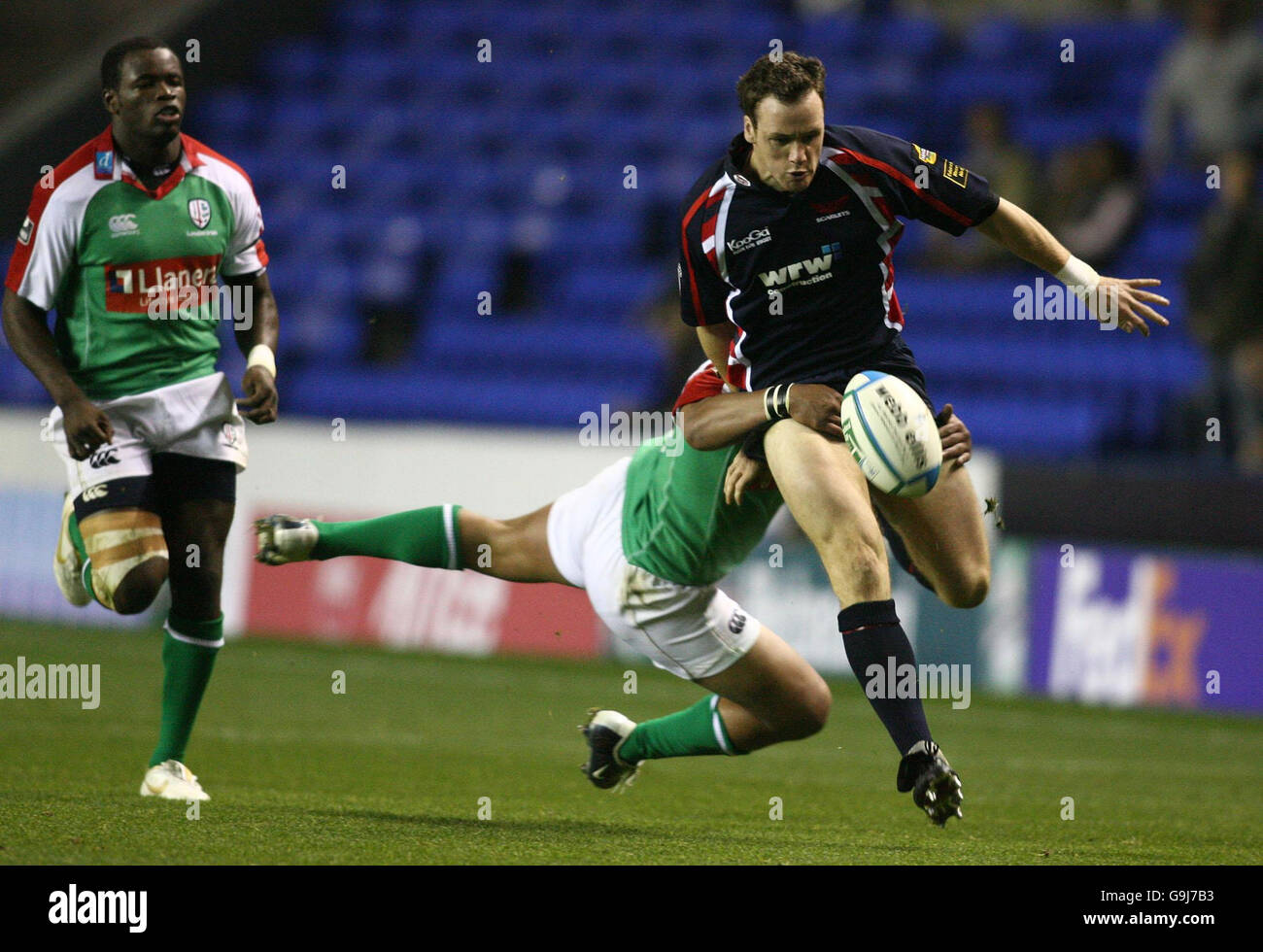 Mark Jones di Llanelli è fermato da un volo da Seilala Mapusua, londinese Irish, durante la partita della Heineken Cup allo stadio Madejski di Reading. Foto Stock