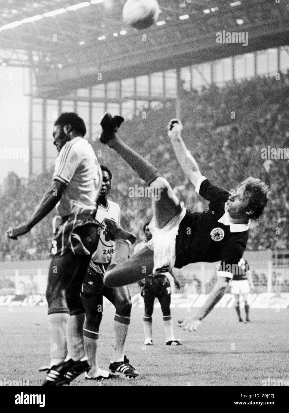 Calcio - Coppa del mondo FIFA Germania occidentale 1974 - Gruppo 2 - Zaire / Scozia - Westfalenstadion, Dortmund. Mwanza Mukombo (l) di Zaire si intromica mentre la Legge scozzese di Denis (c) tenta un calcio d'testa Foto Stock